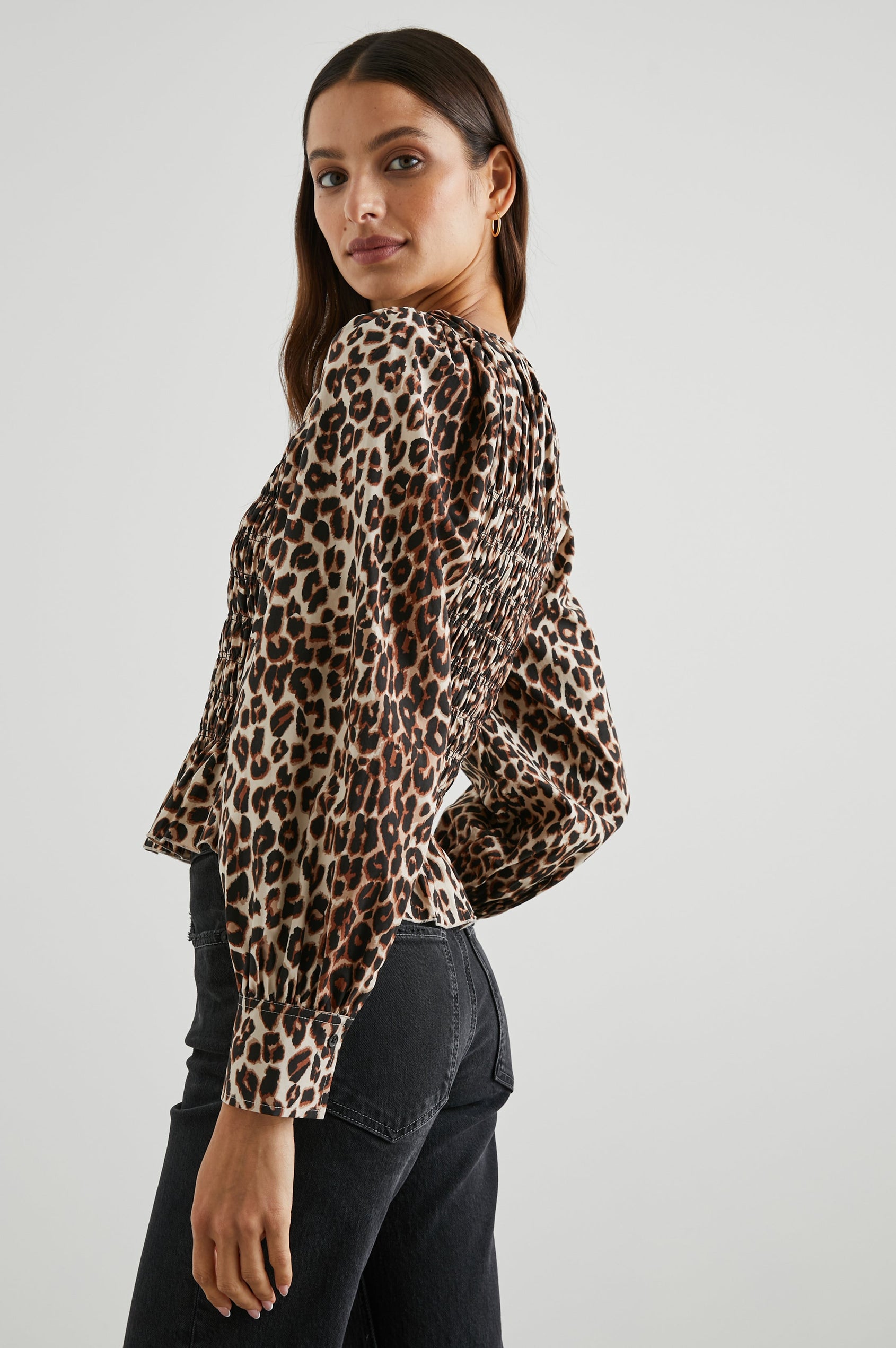 Tari Long-Sleeve Top with Shirring Across the Bodice, a Ruffled Hem, a Scoop Neck and Button Cuffs in Nala Colorway, Brown and Black Spots on White - Side View Featured on Model