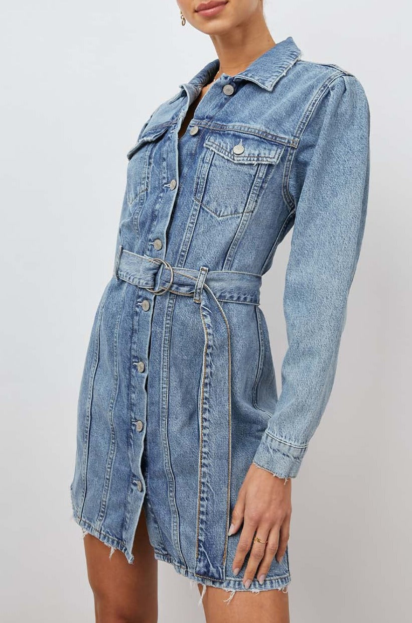 Griffith Long-Sleeve Denim Mini Dress with Buttons Down the Front, a Fabric Double Ring Belt, Two Chest Button Flap Pockets, Frayed Trim and Vertical Seams Down the Front in Indigo Charm Colorway - Front View Featured on Model
