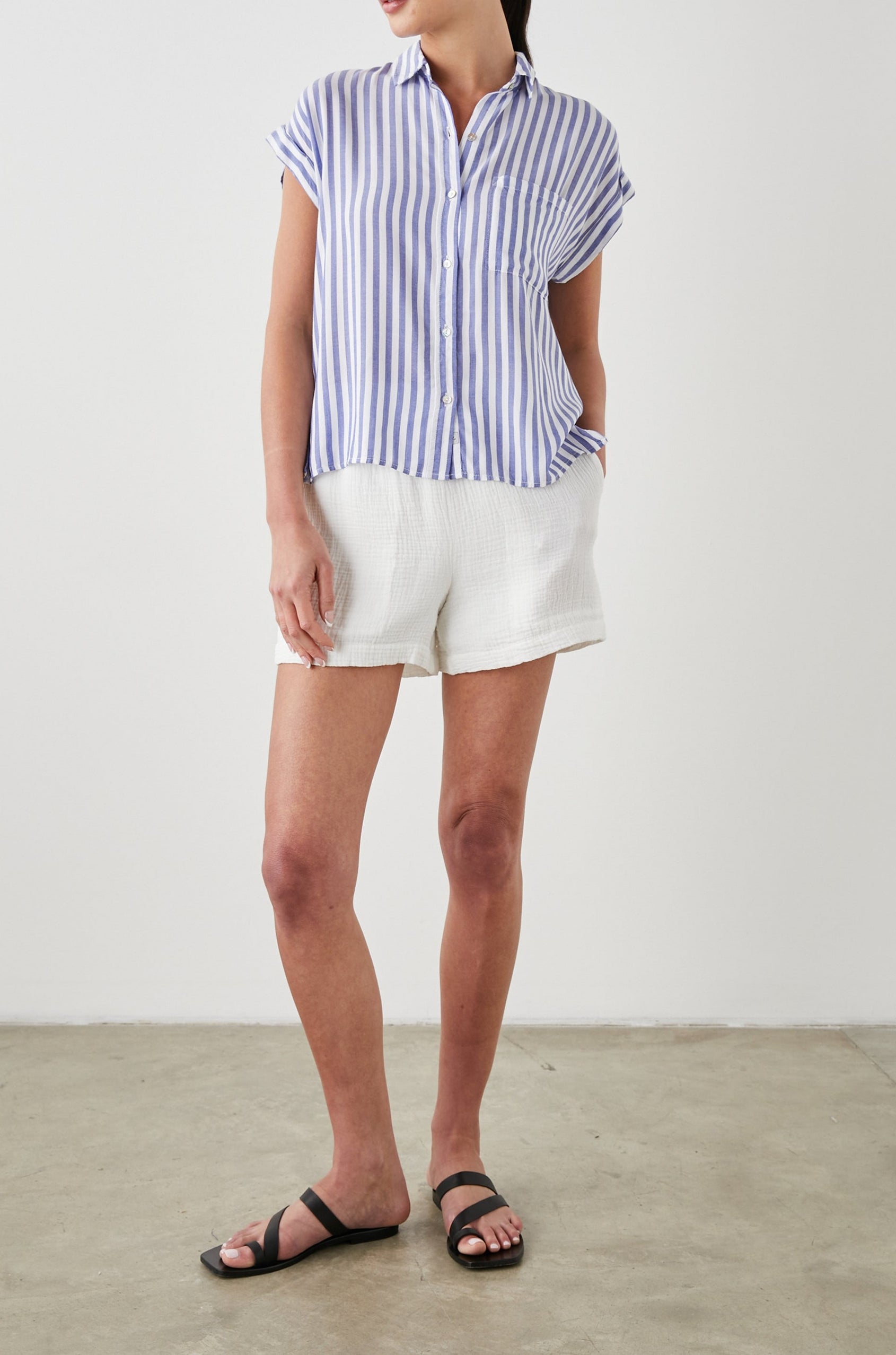 Whitney Short Rolled Sleeves Button Up with a Chest Patch Pocket and Short Side Slits in Blue White Stripe Colorway, with vertical stripes - Front Full Body View Featured on Model