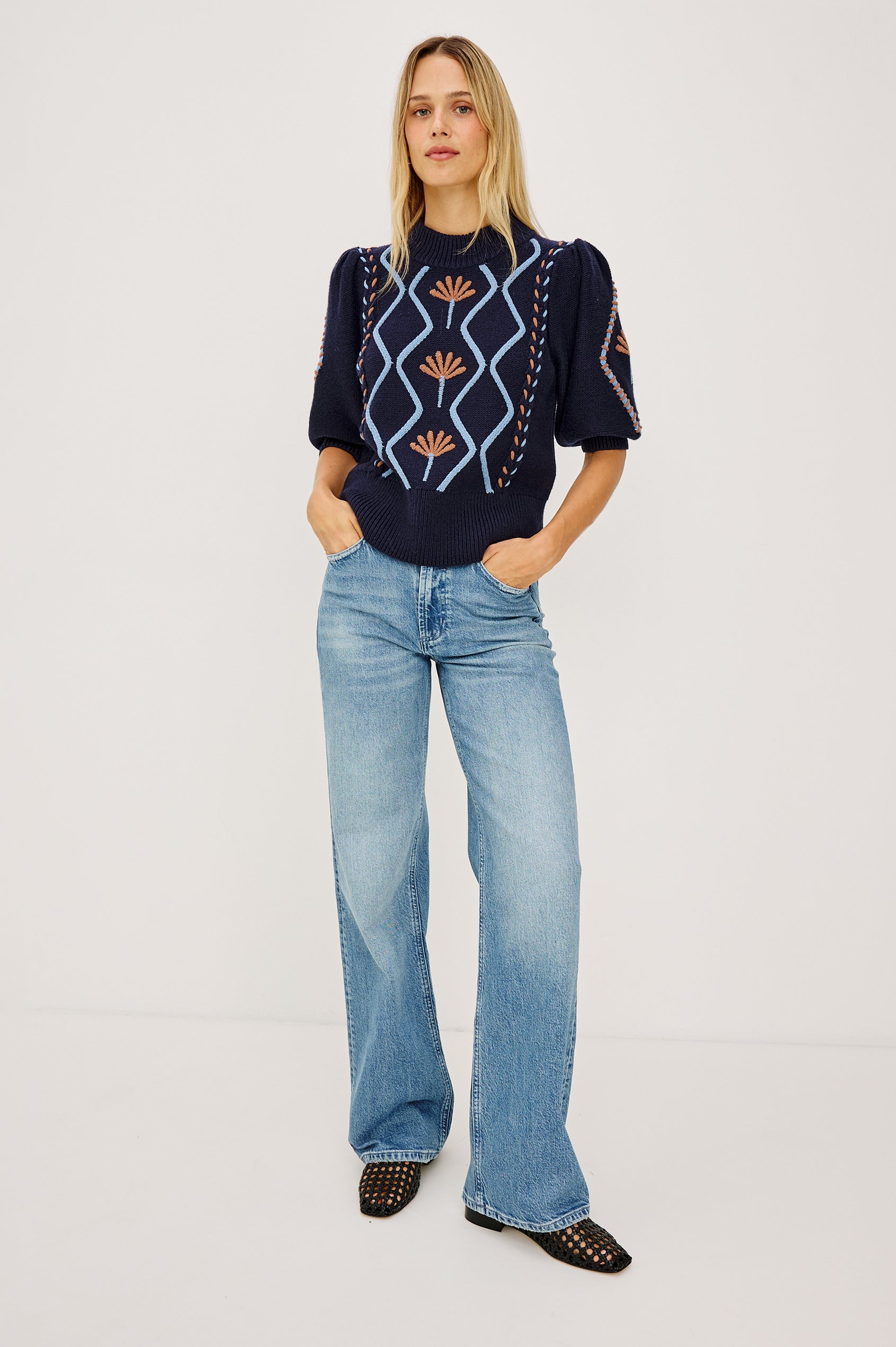Addy Sweater in Cable Knit With Mock Neck, Relaxed Fit, and Elbow-Length Puff Sleeves in Floral Cables - Full Body Front View Featured on Model