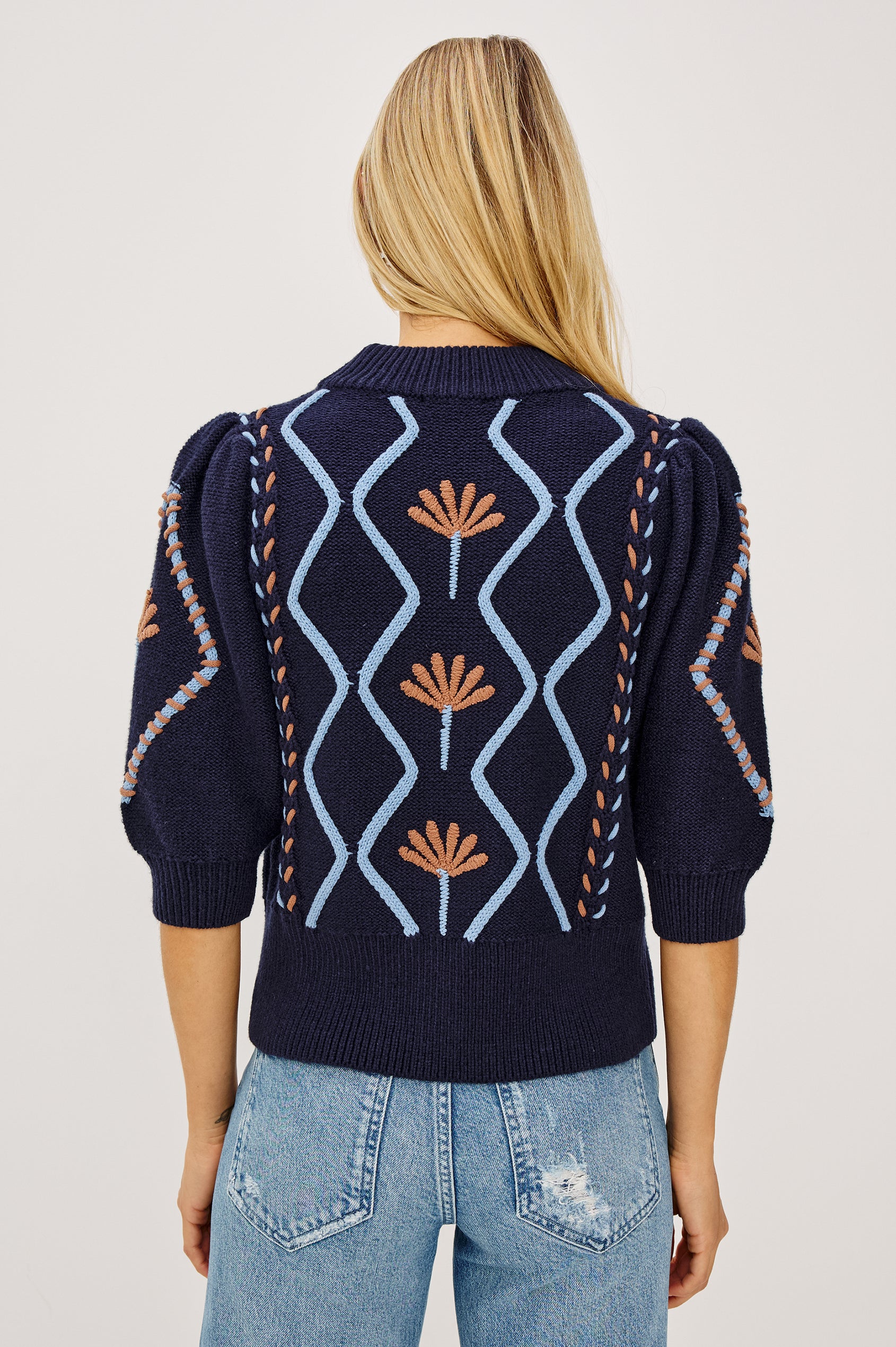 Addy Sweater in Cable Knit With Mock Neck, Relaxed Fit, and Elbow-Length Puff Sleeves in Floral Cables - Upper Body Back View Featured on Model