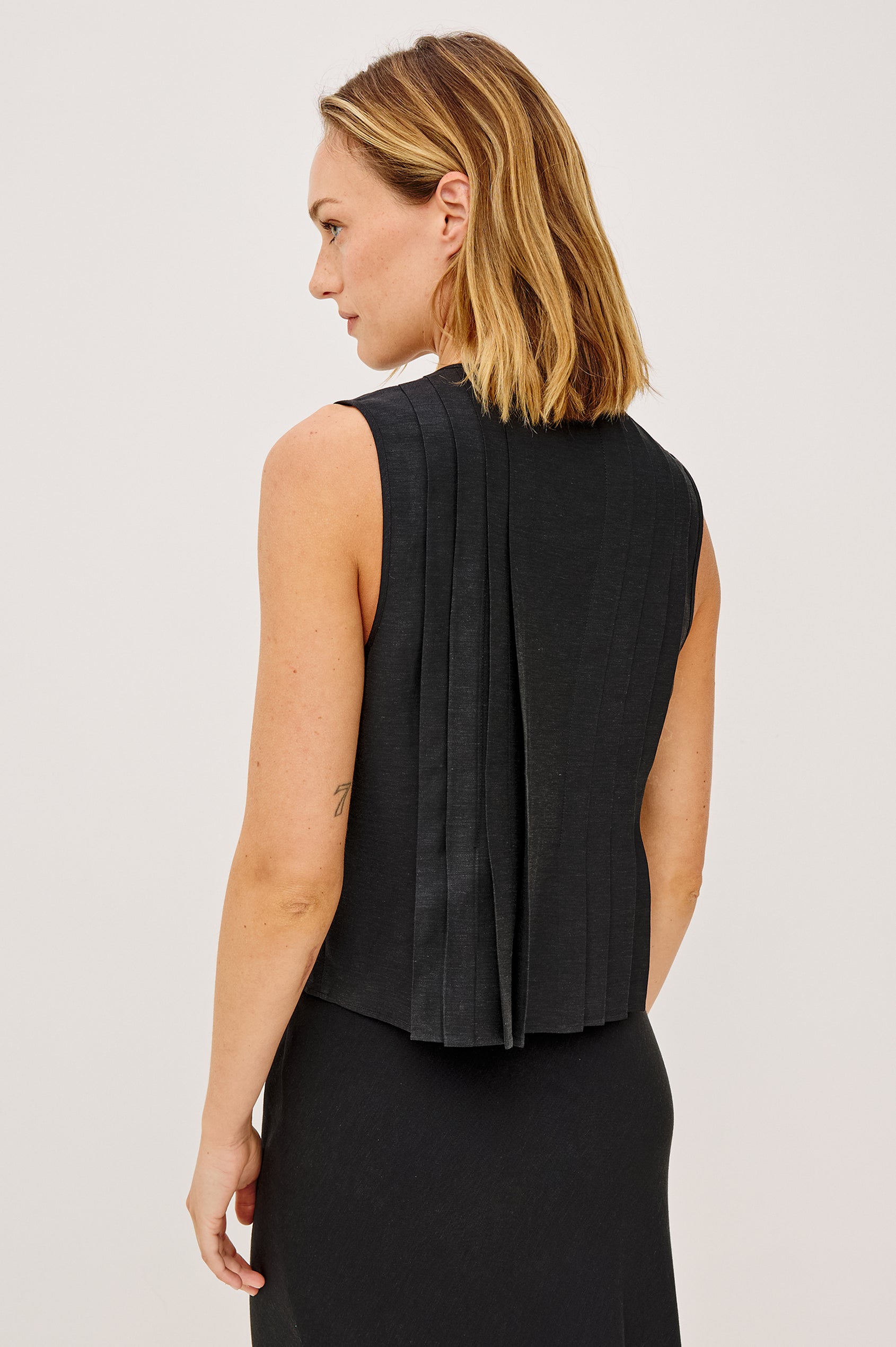 Aja Sleeveless Top in Linen With Plunging V-Neckline, Center-Front Ties, and Front Pleats in Black Linen Colorway - Upper Body Back View Featured on Model