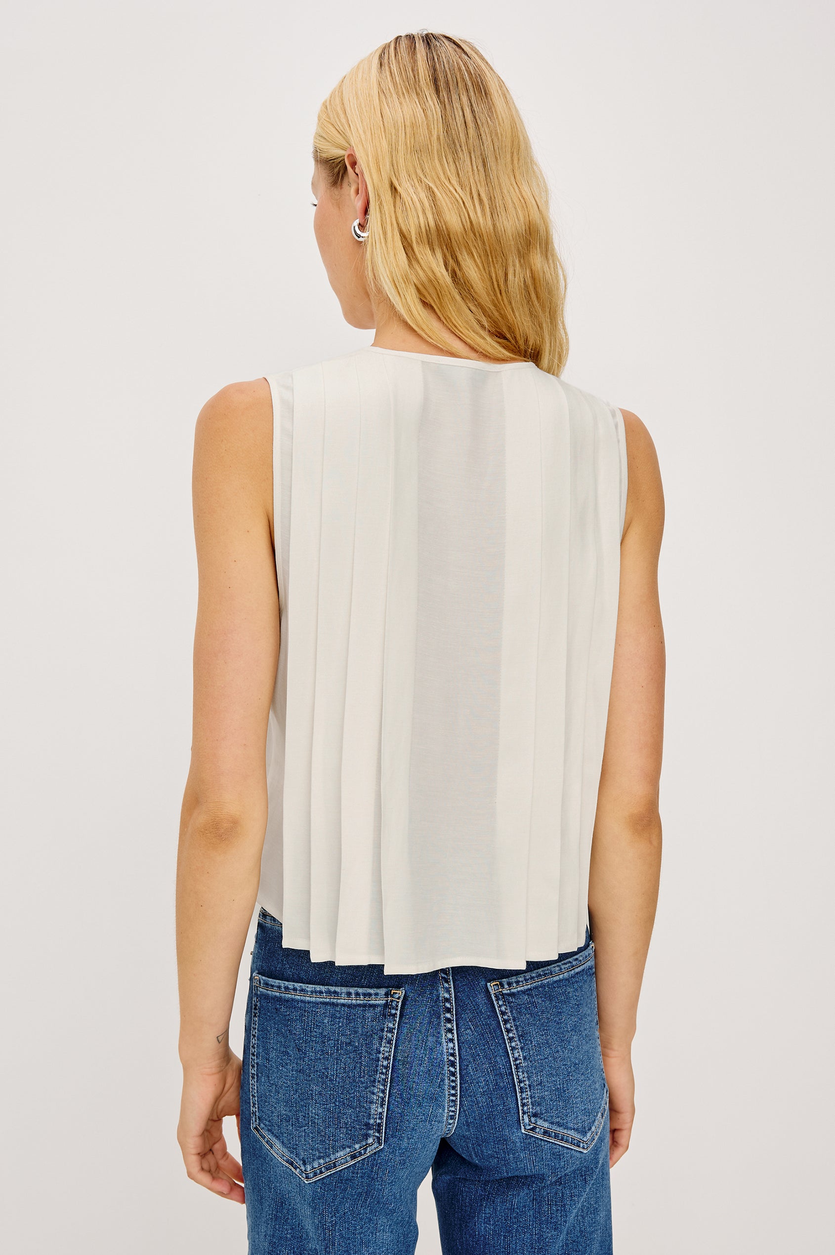 Aja Sleeveless Top in Linen With Plunging V-Neckline and Center-Front Ties and Front Pleats in Ivory Colorway - Upper Body Back View Featured on Model