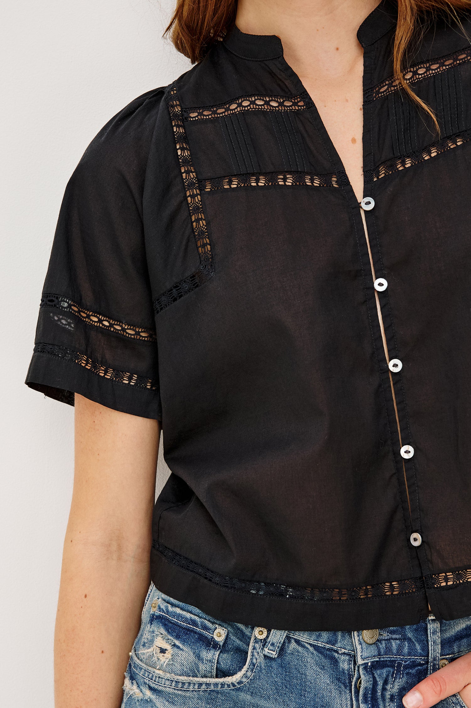 Alanis Shirt in Lightweight Cotton With Split Band V-Neckline, Front Button-and-Loop Closures, Lattice Embroidery, and Short Puff Sleeves in Black Colorway - Upper Body Front View Featured on Model