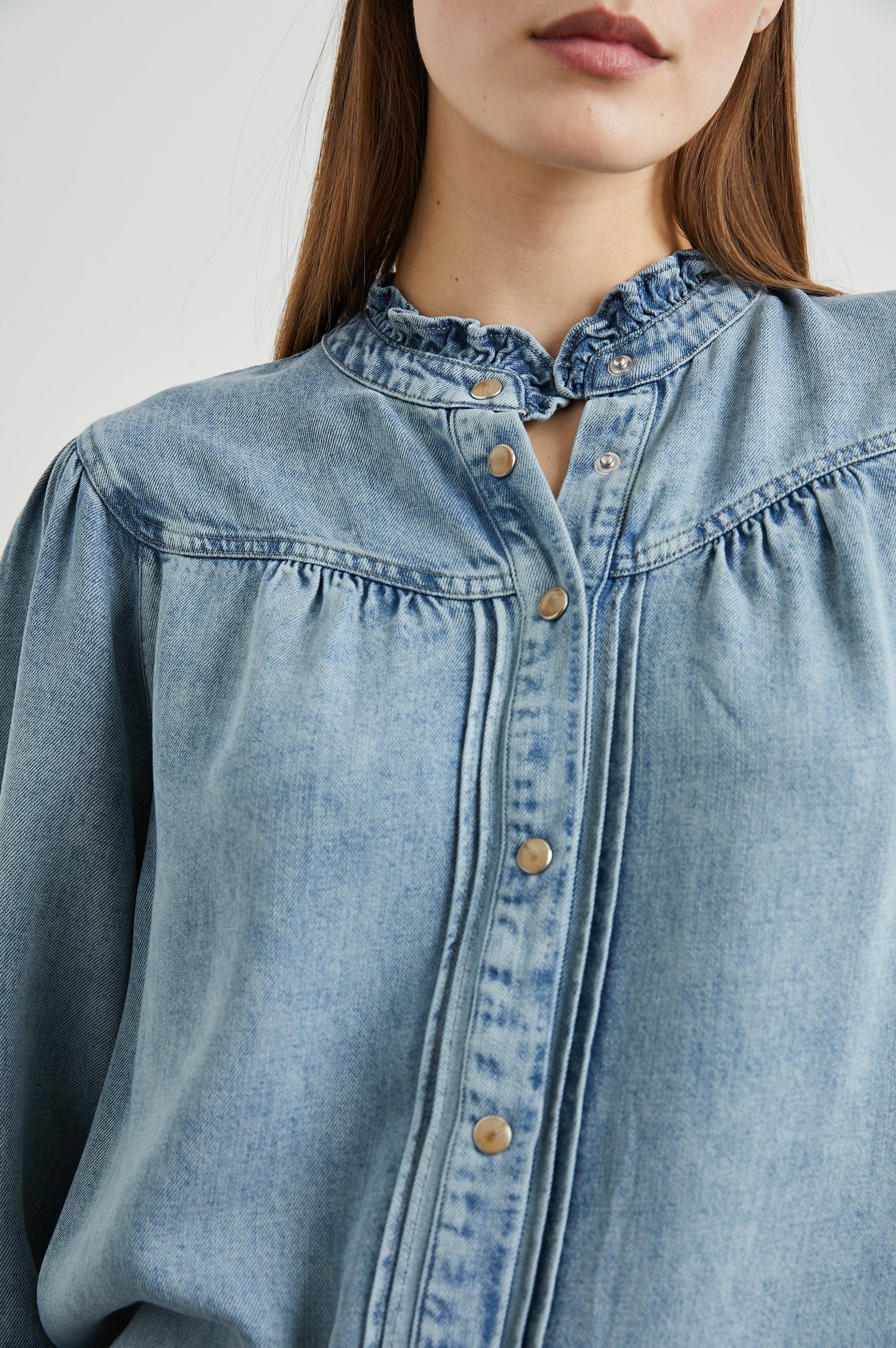 Alanna Long Sleeve Shirt with Snaps Down the Front, a Ruffled Collar, Banded Ruffed Cuffs, and Pleats at the Yoke Seam in Antique Indigo Colorway - Front View Featured on Model