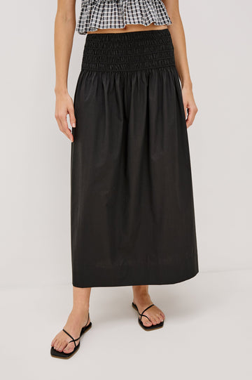 Alessa Midi Skirt with a Wide Elastic Gathered Waistband in Black Colorway. Front View Shown on Model.