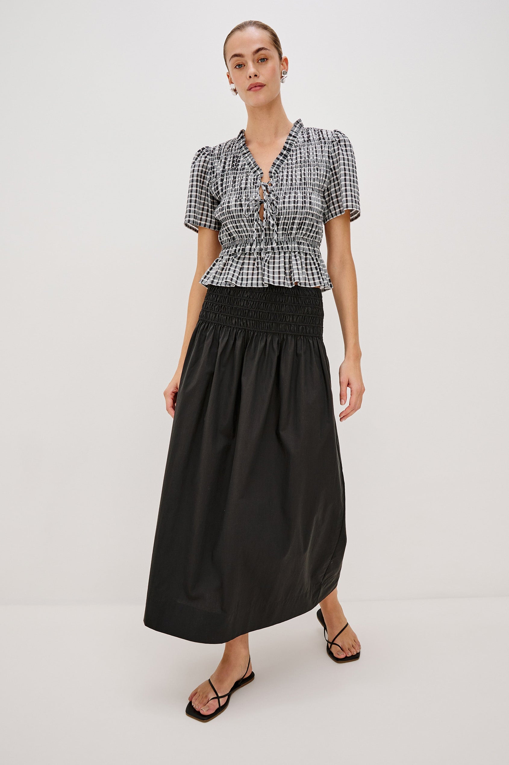 Alessa Midi Skirt with a Wide Elastic Gathered Waistband in Black Colorway. Full Body Front View Shown on Model.
