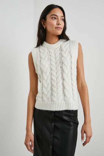 Alexis Sleeveless Cable Knit Sweater Vest with a Crew Neck and Ribbed Trim in Ivory Colorway - Front View Featured on Model 