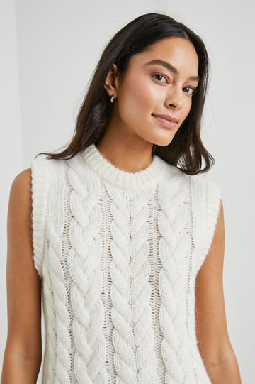 Alexis Sleeveless Cable Knit Sweater Vest with a Crew Neck and Ribbed Trim in Ivory Colorway - Front View Featured on Model 
