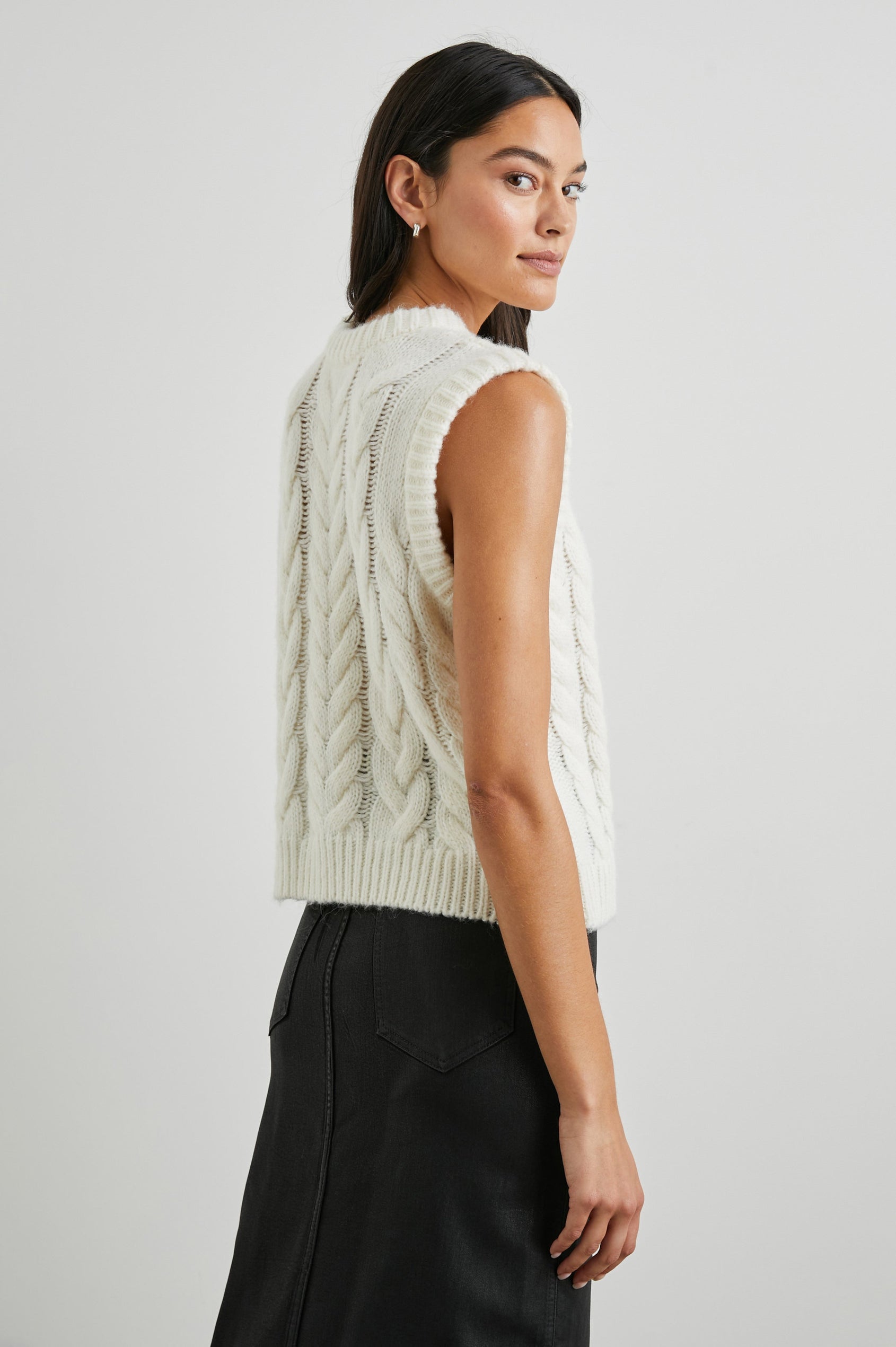 Alexis Sleeveless Cable Knit Sweater Vest with a Crew Neck and Ribbed Trim in Ivory Colorway - Back View Featured on Model 