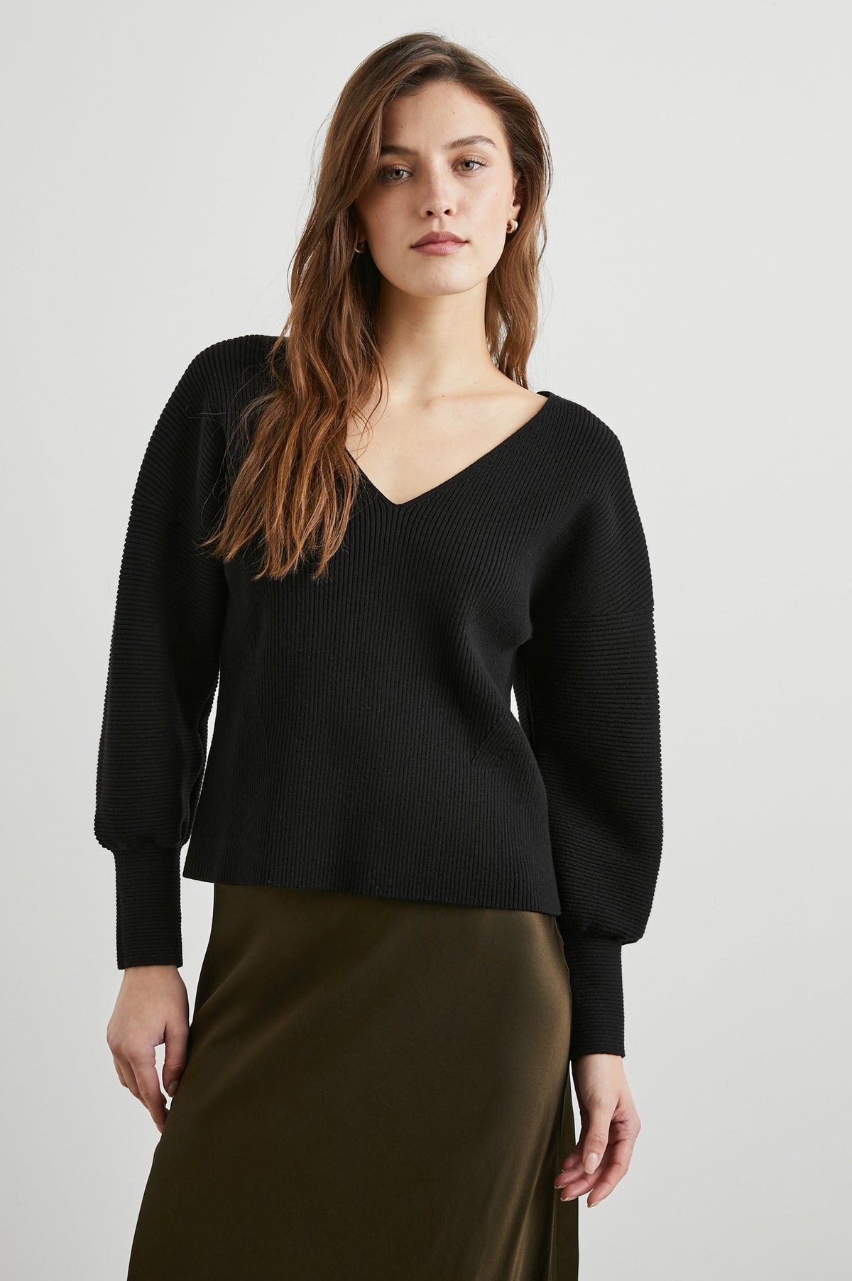 Alondra Ribbed Long-Sleeve Sweater with a Deep V Neck and Puff Sleeves in Black Colorway - Front View Featured on Model 