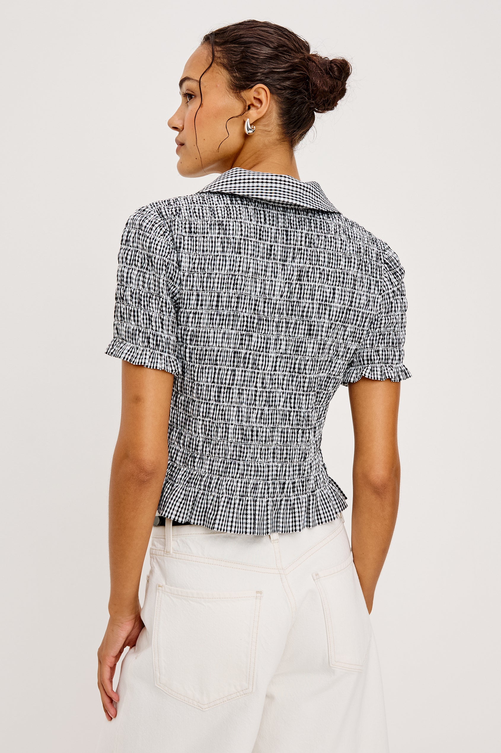 Alton Top in Cotton Poplin With Smocked Body Boxy Cropped Fit Collar Front Buttons Short Puff Sleeves and Ruffle Trim in Black Gingham Colorway - Upper Body Back View Featured on Model