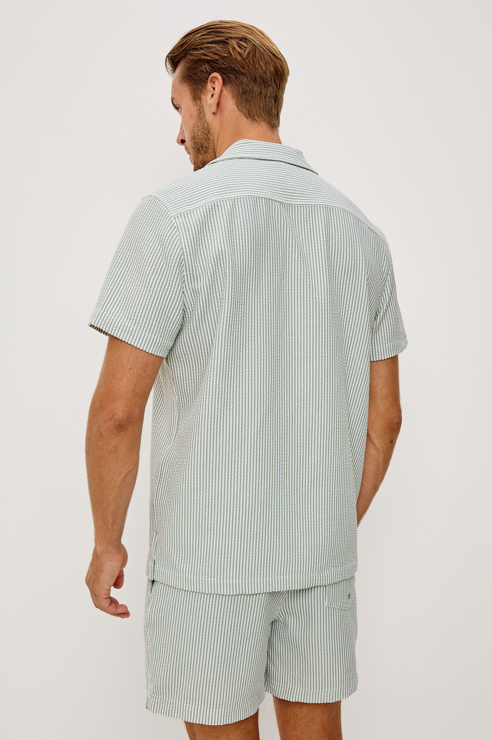 The Amalfi Button-Up Short Sleeve Shirt in Lightweight Stretch Linen-Blend With a Notched Collar and Classic Fit in Sage White Seersucker - Upper Body Back View Featured on Model