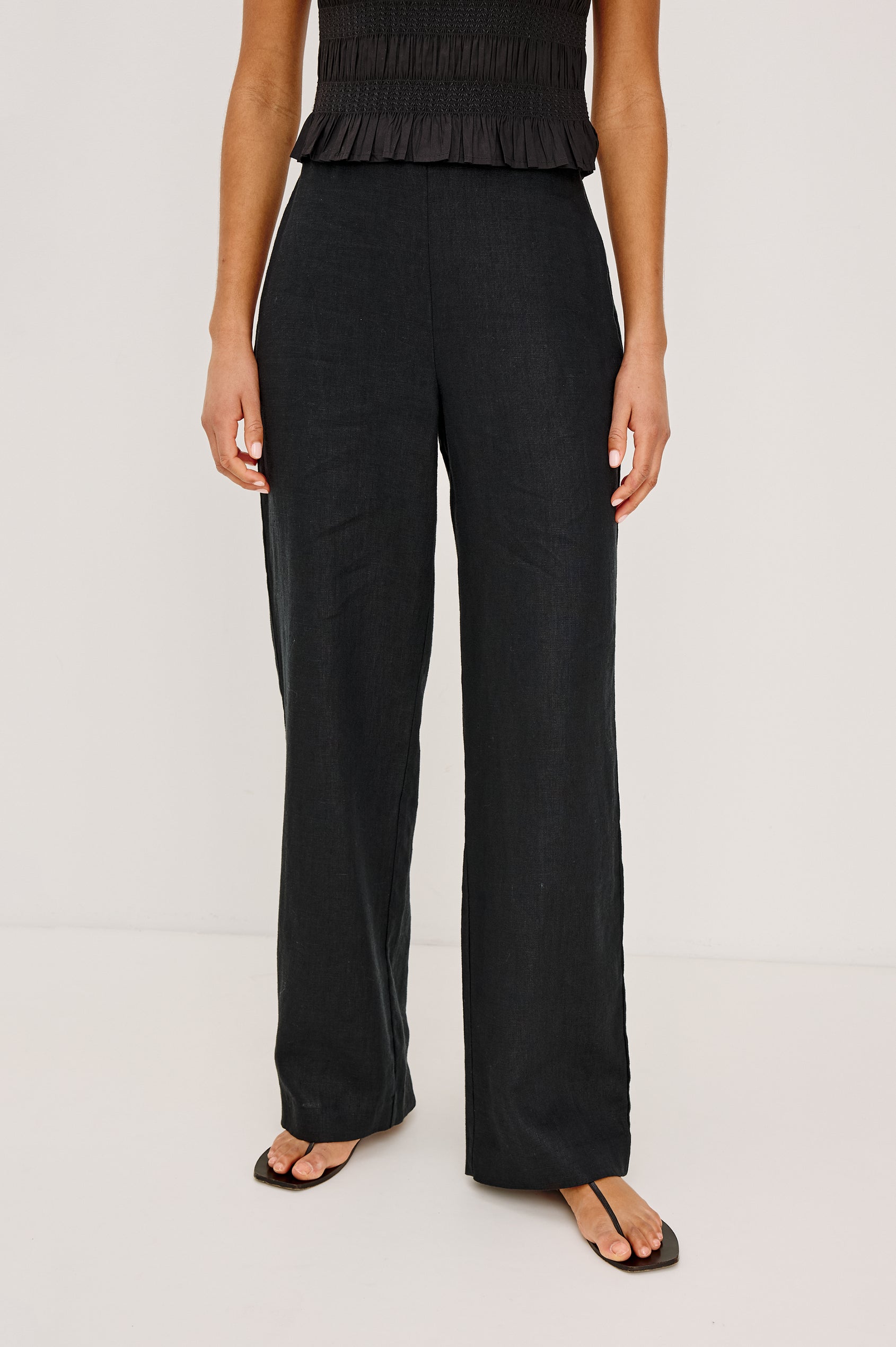 Andrine Pant in Heavy Linen With High-Waisted Fit, Straight Legs, Unlined, Side On-Seam Pockets, Side Zip Closure in Black Colorway - Lower Body Front View Featured on Model