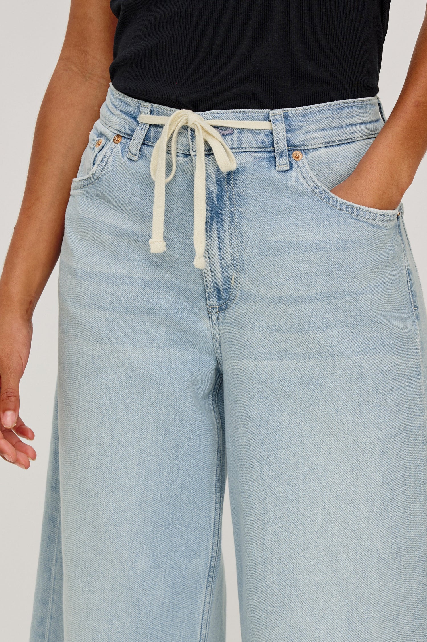 Angeleno Crop Denim Pant, Wide Leg, Five Pocket Zip Fly with a White Drawstring Tie at Waist in Light Wash Scuba Colorway. Front Detailed View Shown on Model.