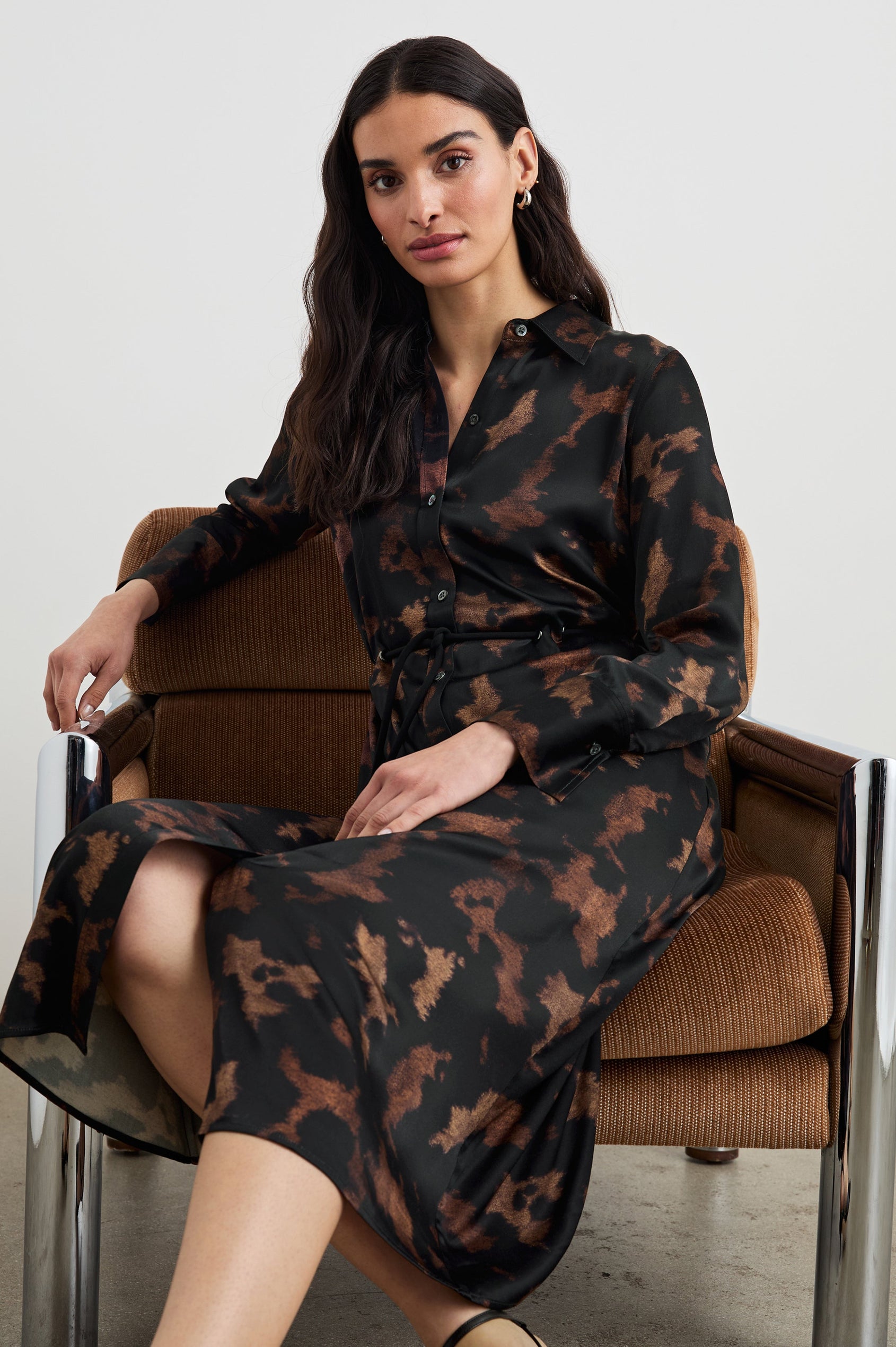 Anina Long-Sleeve Midi Dress with Buttons Down the Front, a Collar, Button Cuffs, and a Cord Belt in Diffused Sandstone Colorway, a pattern in black and browns - Front Full Body View Featured on Seated Model