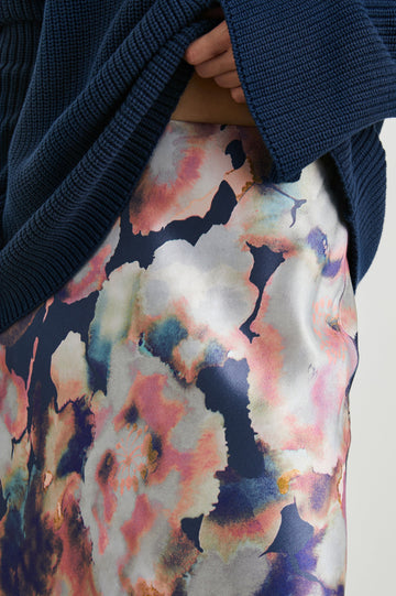 Anya High-waisted Midi Skirt in Midnight Verbena Colorway, Flowers in Pinks, Purples, Oranges and Blues on dark blue - Front View Featured on Model