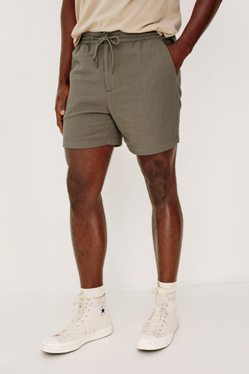 Archer Short in Unlined Cotton Linen With Relaxed Fit, Adjustable Waist Drawstring Ties, Side Pockts, and 6-Inch Inseam in Fallen Rock Colorway - Lower Body Front View Featured on Model