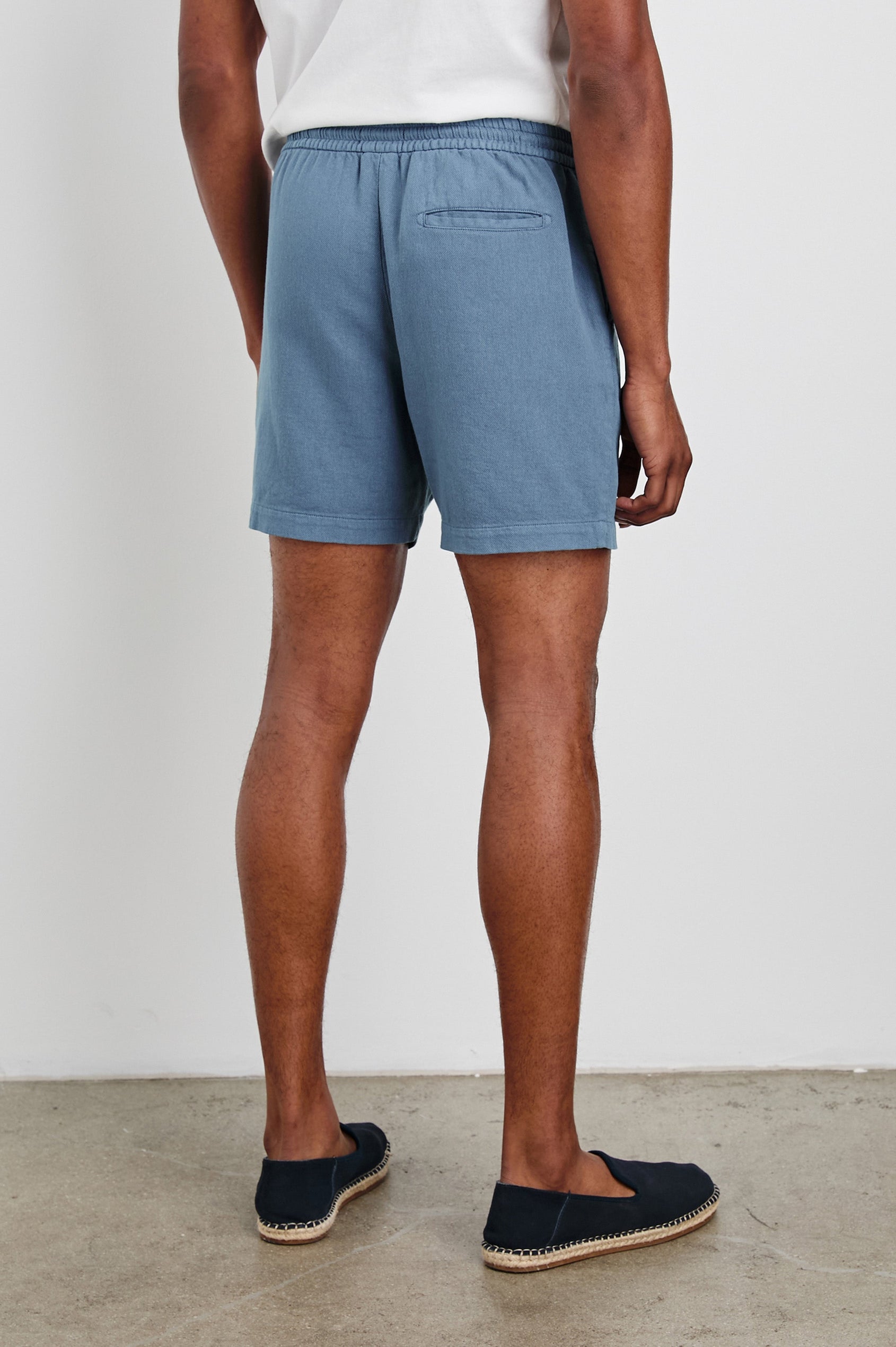 Archer 6" Shorts with a Drawstring Waist, Zipper Fly with Button, Two Front Pockets and a Back Patch Pocket in Washed Blue Colorway - Back View Featured on Model