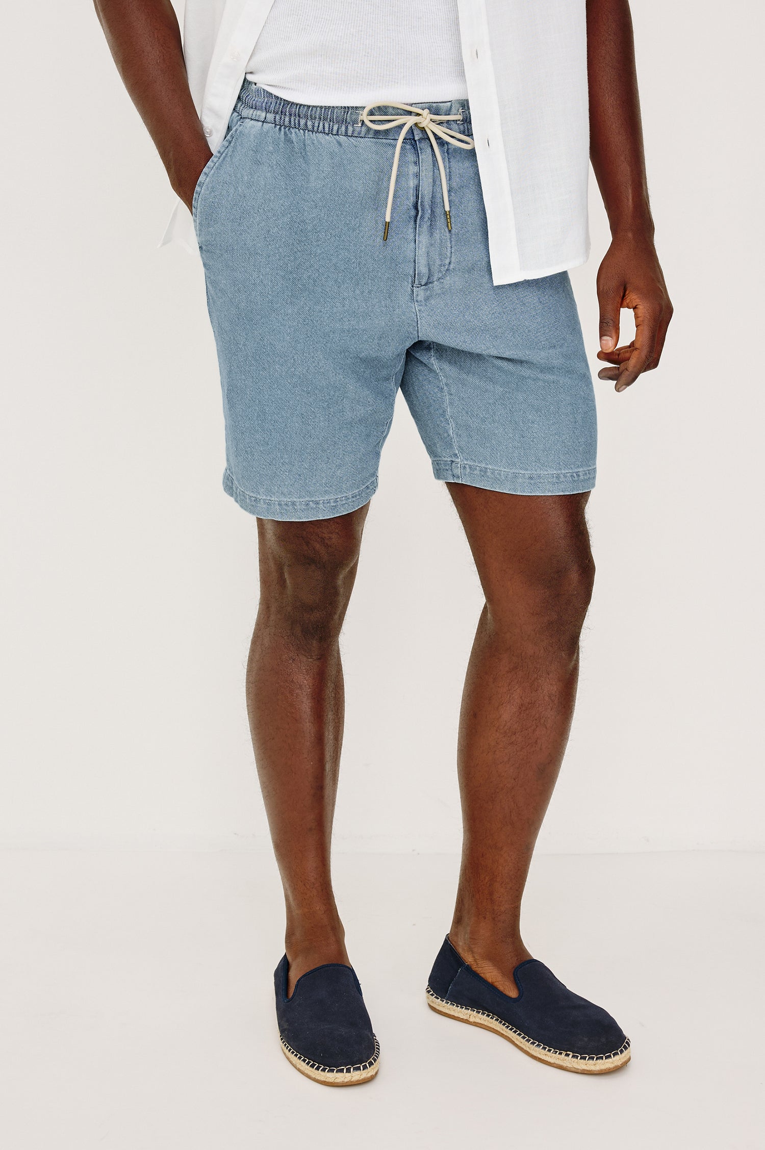 Archer Short in Unlined Cotton Linen With Relaxed Fit, Adjustable Waist Drawstring Ties, Side Pockts, and 8.5-Inch Inseam in Medium Wash Indigo Colorway - Lower Body Front View Featured on Model