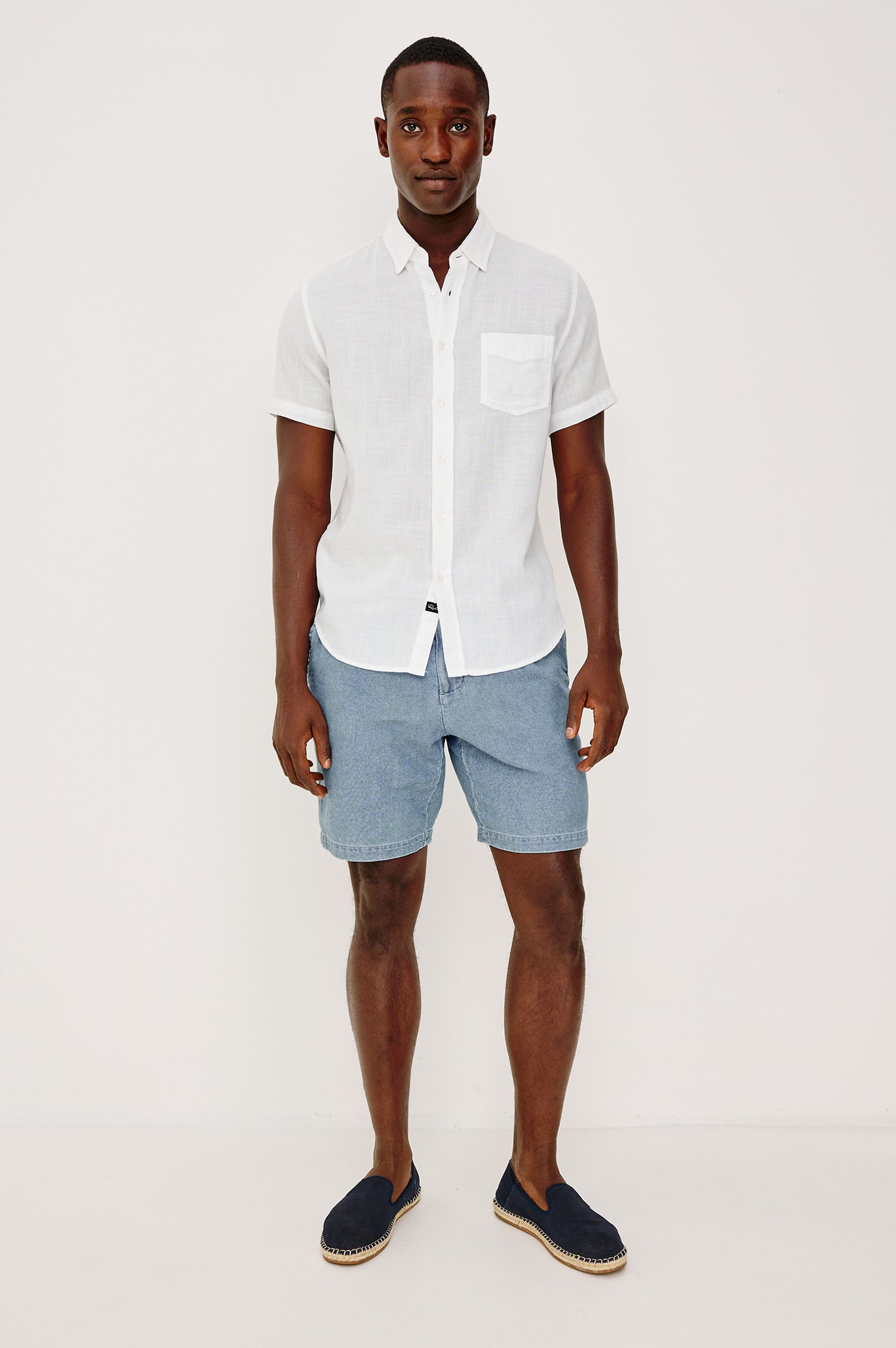 Archer Short in Unlined Cotton Linen With Relaxed Fit, Adjustable Waist Drawstring Ties, Side Pockts, and 8.5-Inch Inseam in Medium Wash Indigo Colorway - Full Body Front View Featured on Model