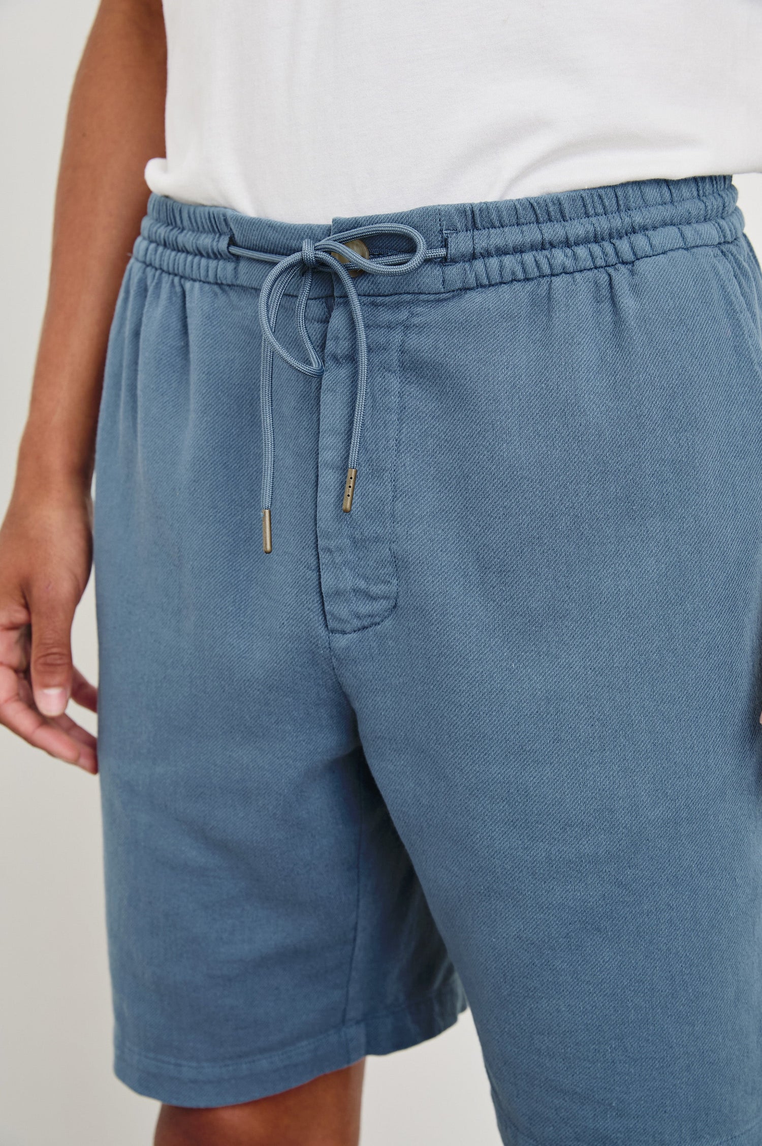 Archer long length cotton short with adjustable drawstring and front button closure in Washed Blue - front view on model
