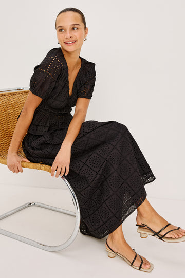 Argenta Top in Cotton Voile With Embroidered Pattern, Short Puff Sleeves, Hook-and-Eye Closure, Elastic V-Neckline and Waist, and Peplum Hem in Black Grid Embroidery Colorway - Stylized View Featured on Model