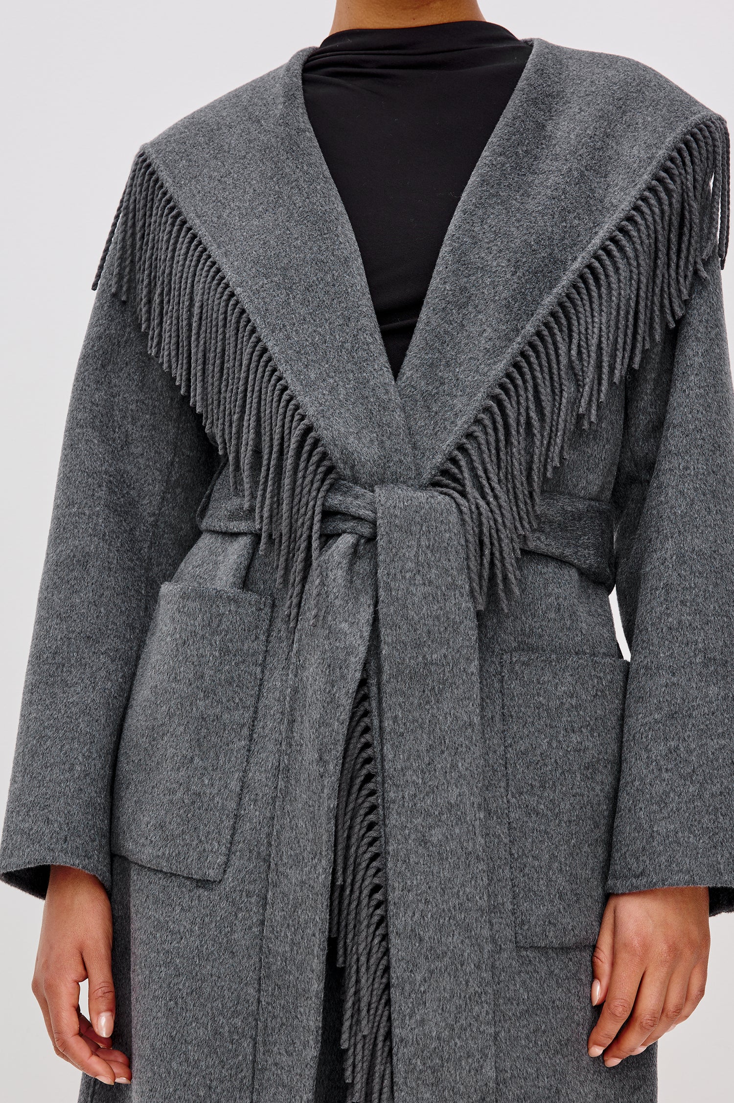 Arlon Coat in Wool Blend With Hood, Shawl Collar, Fixed Hood, Fringe Trim, Adjustable tie belt, Side Patch Pockets, and Long Sleeves in Heather Charcoal Colorway - Upper Body Close Up View Featured on Model