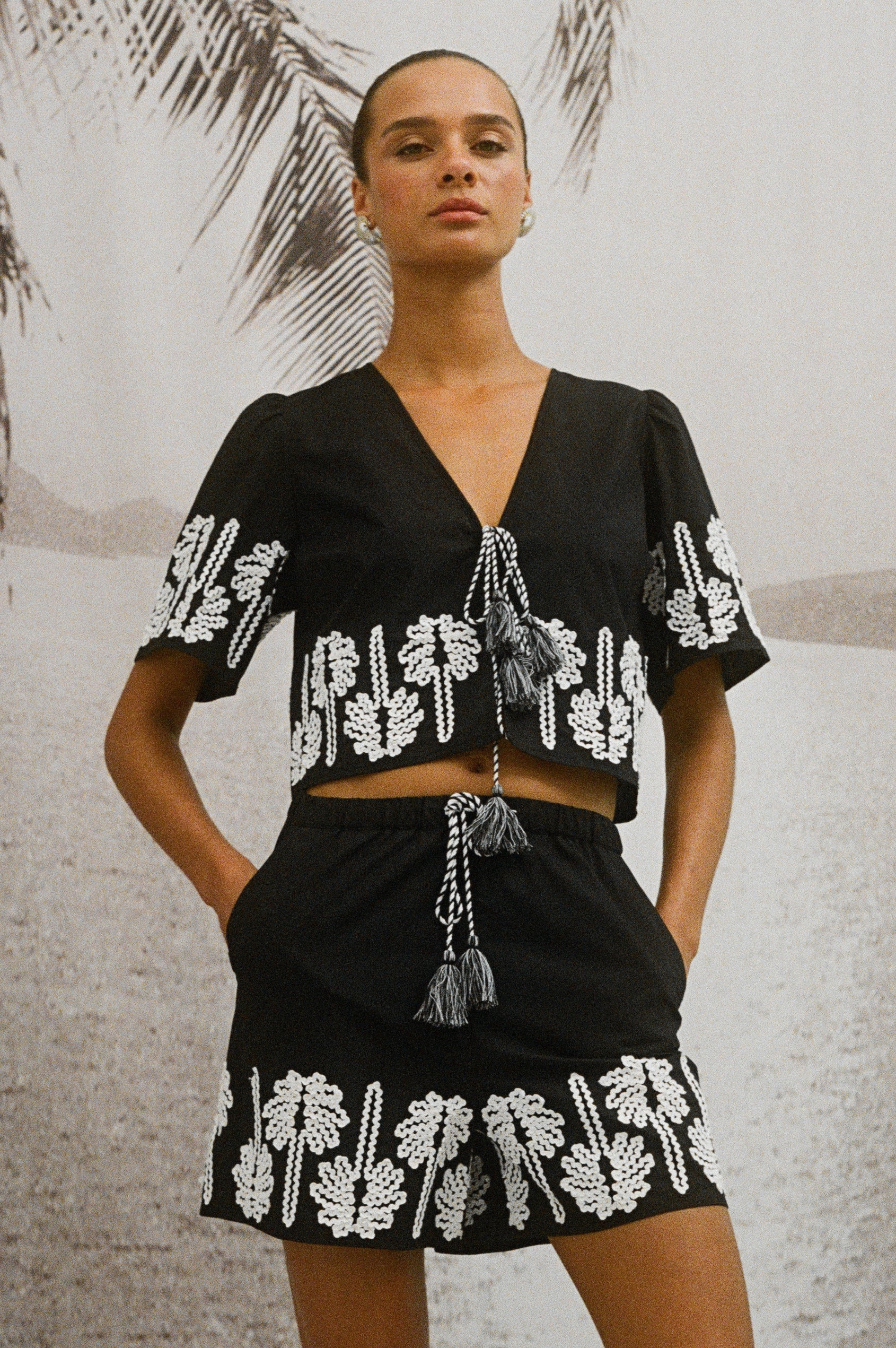 Armanda Black Shorts with Ivory Palm Tree Stitching at the hem and waistline cord ties - front view on model