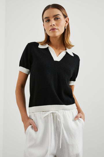 Arya Short Sleeve Top with a V Neck and Collar in Black Colorway, with White Trim - Front View Featured on Model 