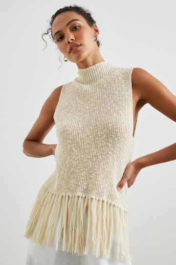 Astrid Sleeveless Knit Top with a Mock Neck, Fringe at the Hem, and Wide Arm Openings in Ecru Colorway - Front View Featured on Model 