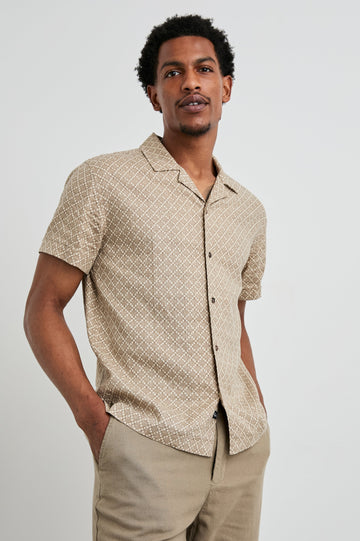 Atlas Short-Sleeve Button Up in Ikat Oat Colorway, with a diamond pattern in browns - Front View Featured on Model