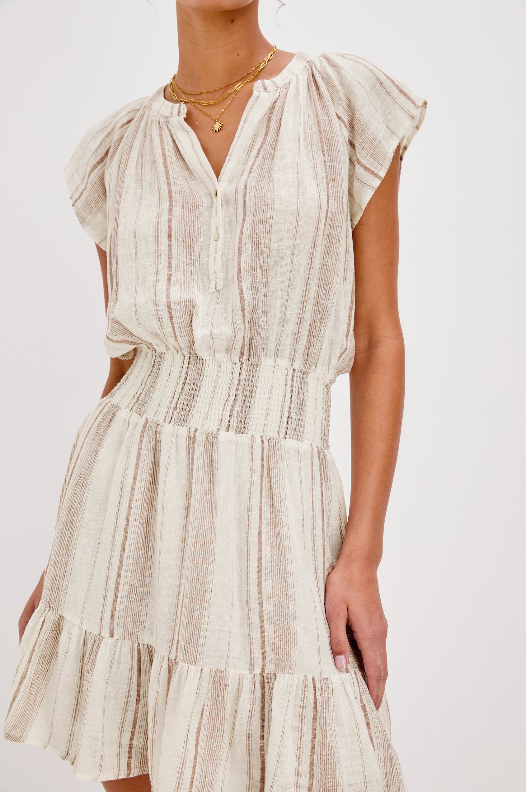 Augustine Mini Dress with Flutter Sleeves, V-Neck Button Front, Elastic Gathered Waist and a Tiered Flounce Hem in Jalisco Stripe Colorway. Front Detailed View Shown on Model.