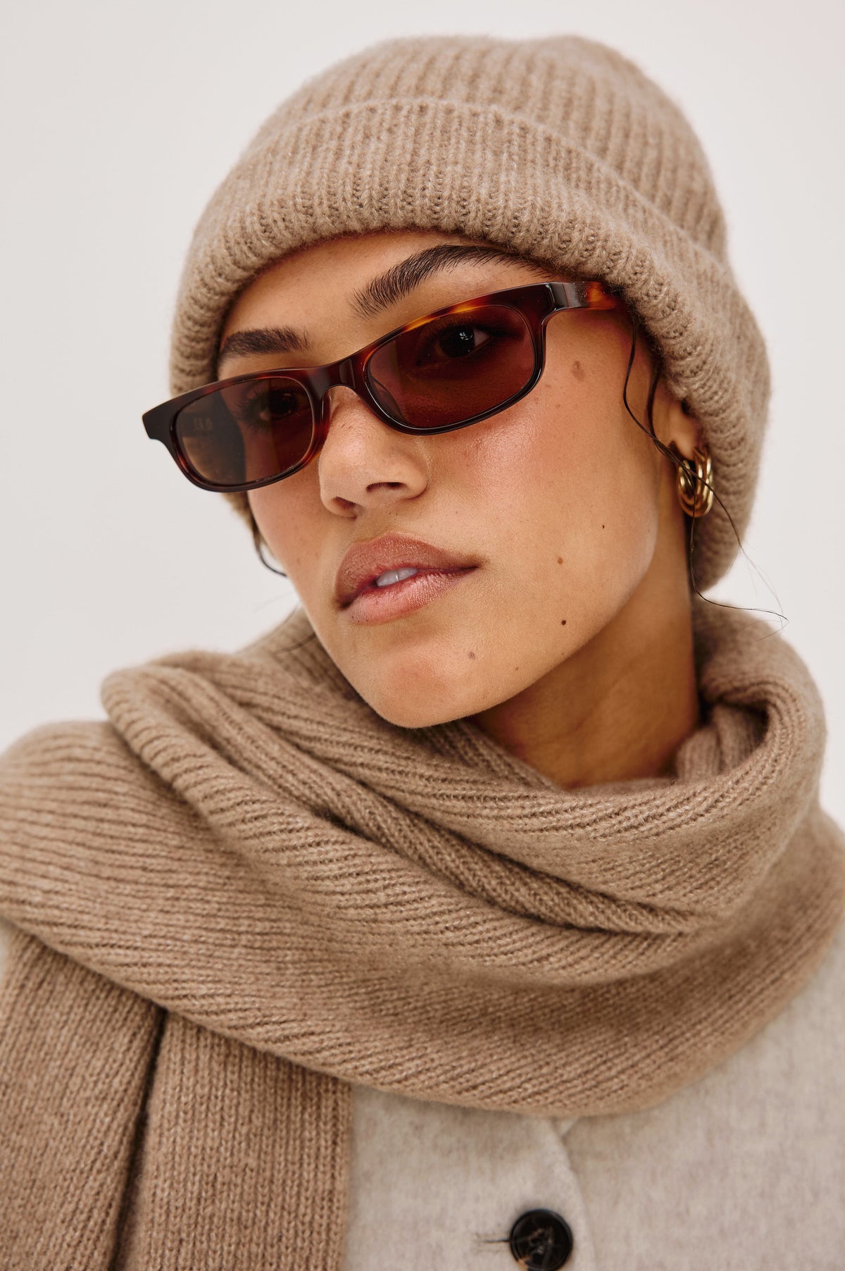 Autumn cashmere beanie in Oat colorway. Front side view featured on model.