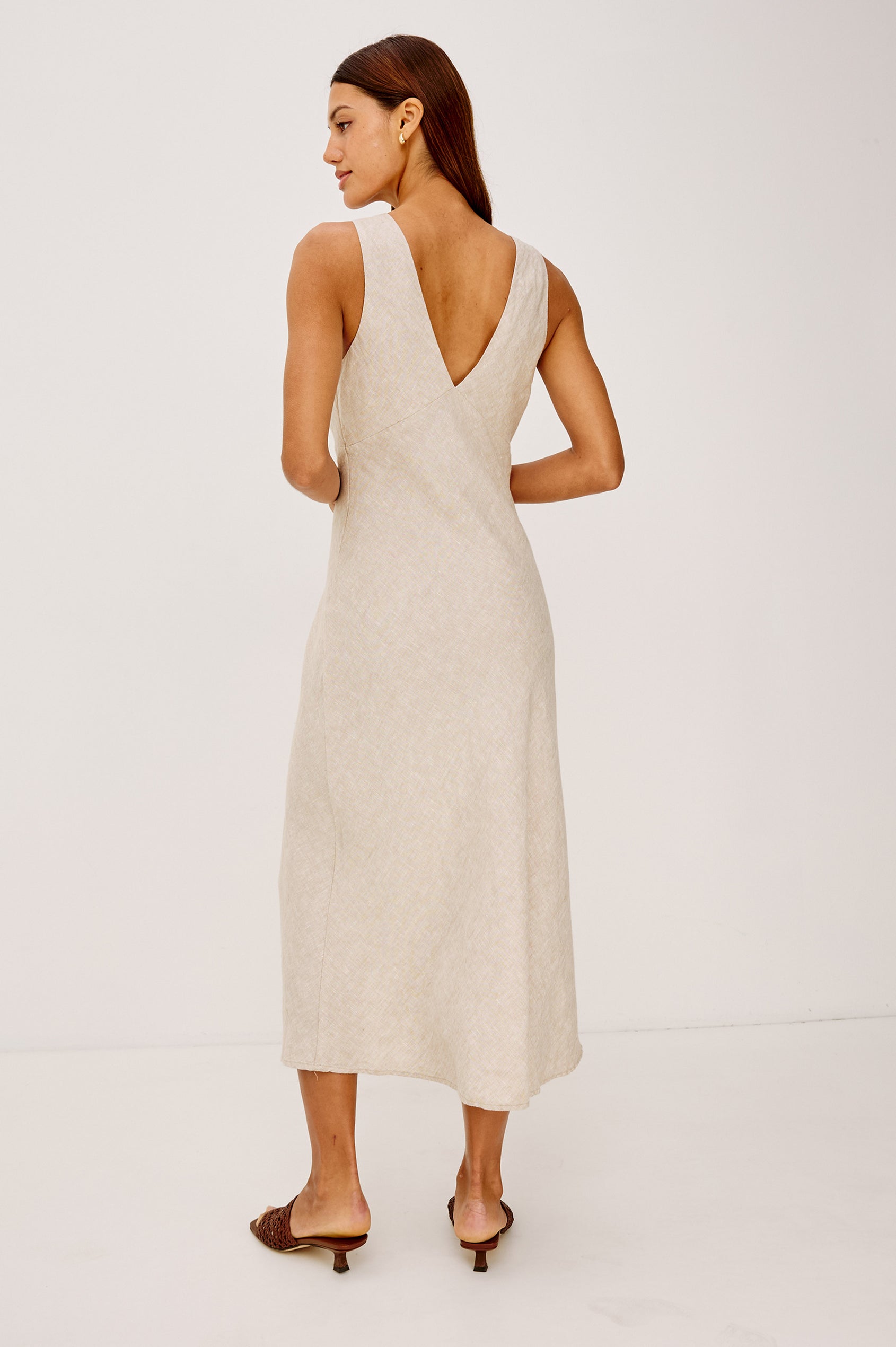 Avianna Midi Dress in Linen With Sleeveless Bias Cut, Plunging V-Neckline, Empire Waist, and Hidden Side Zip in Heathered Flax Colorway - Full Body Back View Featured on Model