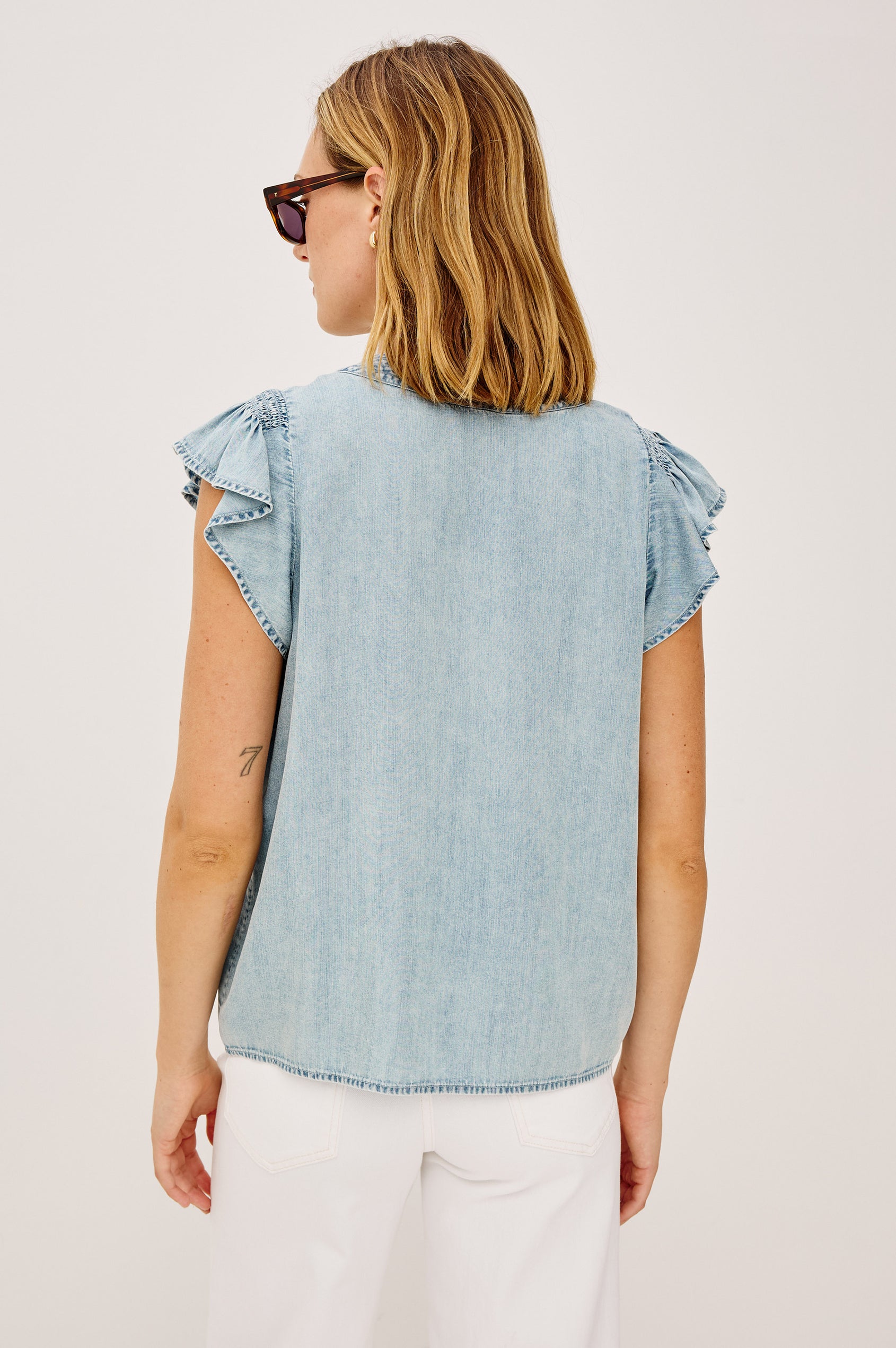Aviva Top in TENCEL™ Denim With Smocked Flutter Sleeves, Split V-Neck With Embroidered Collar and Self-Ties, and Front Buttons in Bleached Indigo Colorway - Upper Body Back View Featured on Model