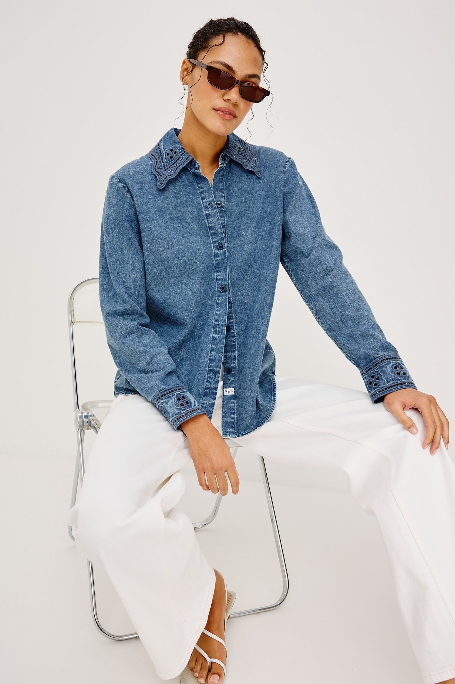 Bethany Button-Up Shirt in TENCEL™ Denim With an Embroidered Collar Long Sleeves and Loose Fit in Antique Blue Colorway - Full Body View Featured on Model Sitting