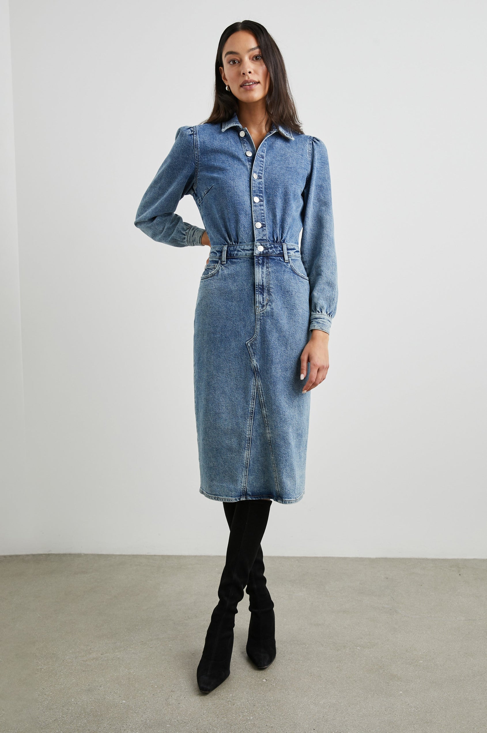 Beverly Long Sleeve Denim Knee Dress with a Back Vent, Belt Loops, a Button and Zipper Closure for the Skirt and Button Closure on the Bodice, a Collar, two Front Pockets plus a Coin Pocket and Two Back Patch Pockets in West Coast Colorway, a Blue - Front Full Body View Featured on Model