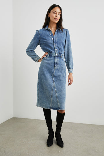 Beverly Long Sleeve Denim Knee Dress with a Back Vent, Belt Loops, a Button and Zipper Closure for the Skirt and Button Closure on the Bodice, a Collar, two Front Pockets plus a Coin Pocket and Two Back Patch Pockets in West Coast Colorway, a Blue - Front Full Body View Featured on Model