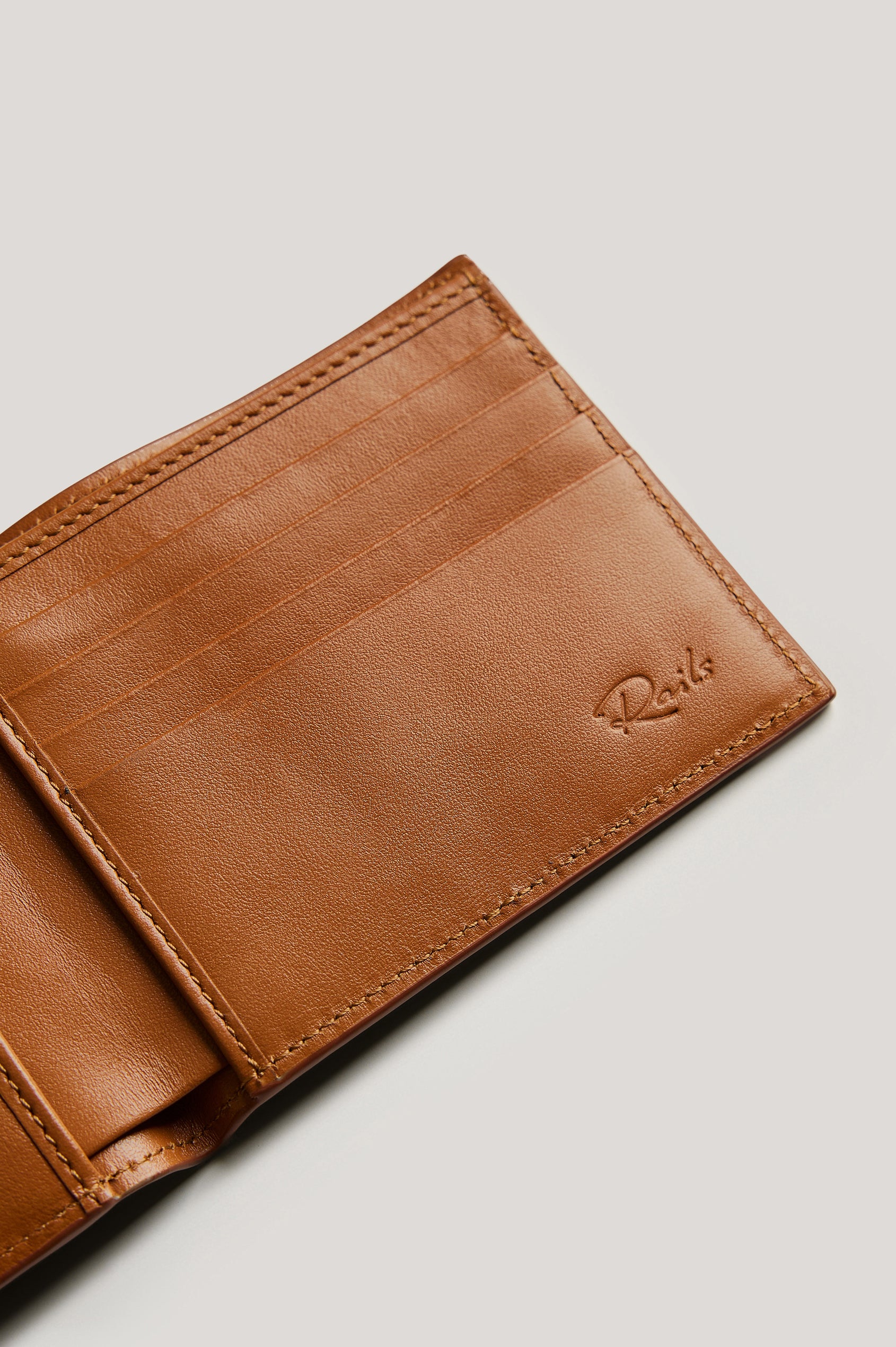 Leather wallet in cognac color, folded. Close up of inside view featured.