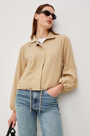 Blake Oversized Cropped Jacket With High Funnel Neck Double-Button Closures Long Drop Shoulder Sleeves With Elastic Cuffs Side Pockets and Drawstring Hem in Almond Colorway - Upper Body Front View Featured on Model
