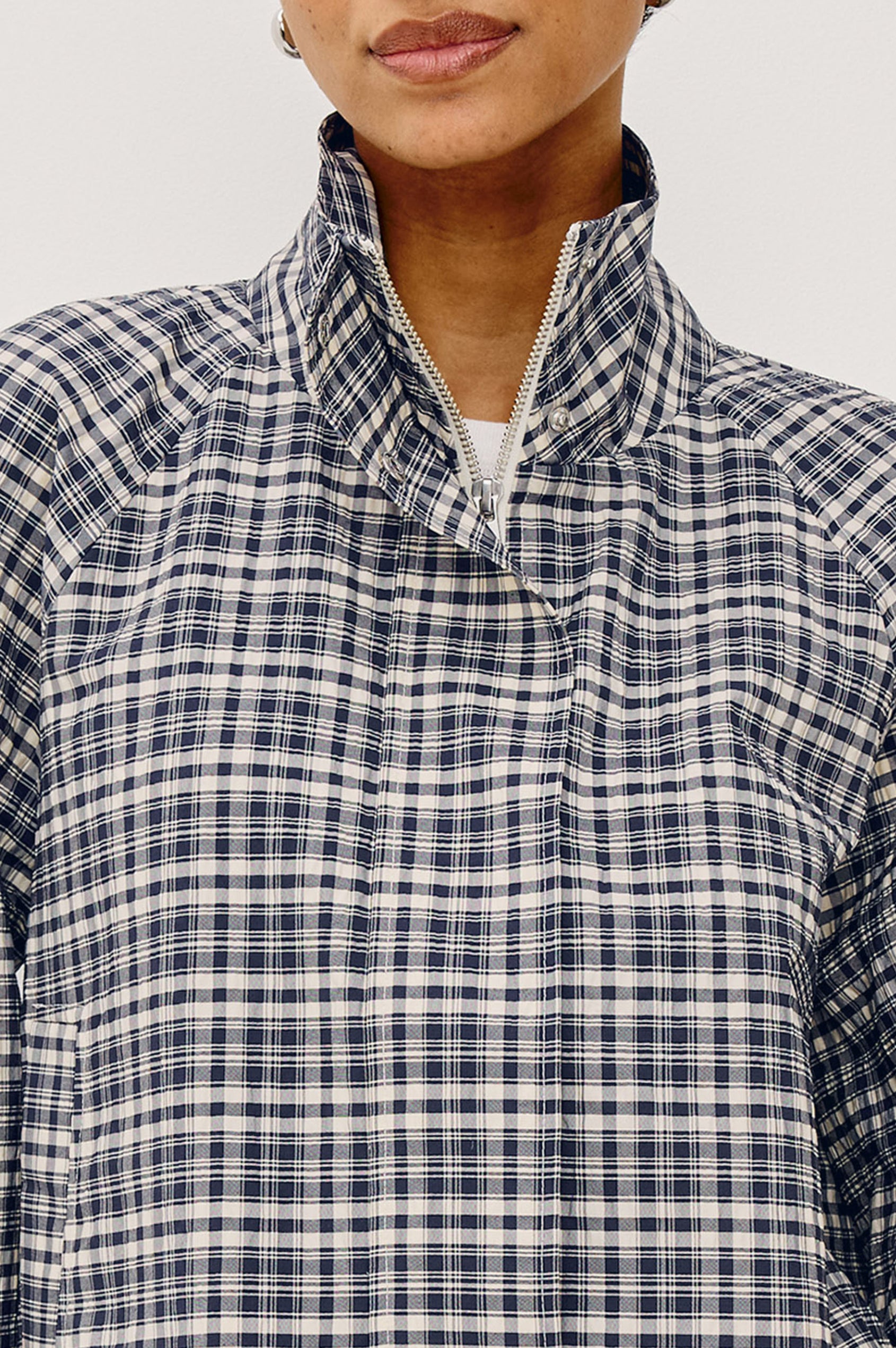 Blake Jacket in Crinkle Nylon Blend With Relaxed Fit, High Funnel Neck, Double Button Closures, Drop Shoulder Sleeves With Elastic Cuffs, and Cropped Drawstring Hem in Mini Check Colorway - Upper Body Front View Featured on Model