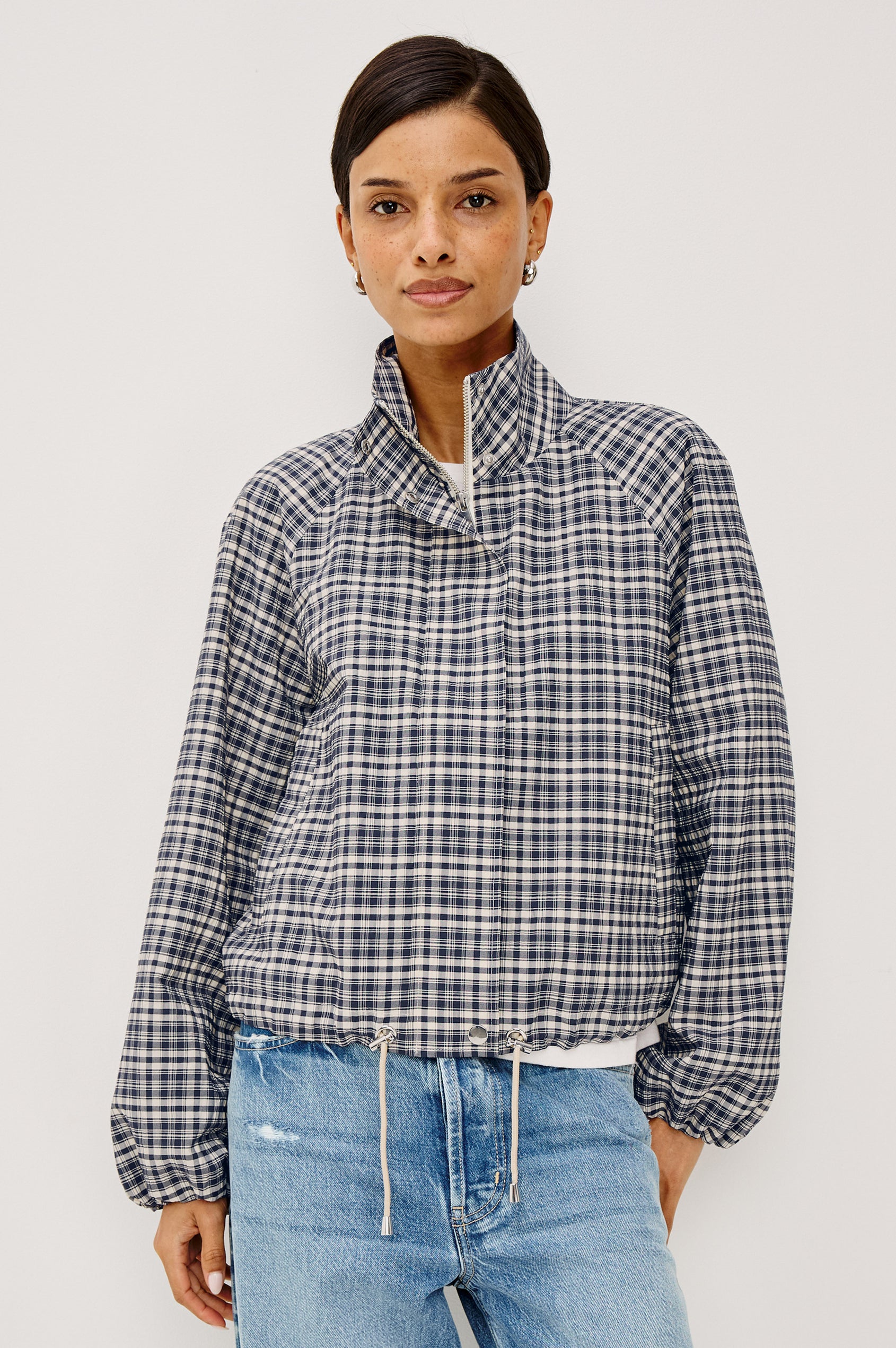 Blake Jacket in Crinkle Nylon Blend With Relaxed Fit, High Funnel Neck, Double Button Closures, Drop Shoulder Sleeves With Elastic Cuffs, and Cropped Drawstring Hem in Mini Check Colorway - Upper Body Front View Featured on Model