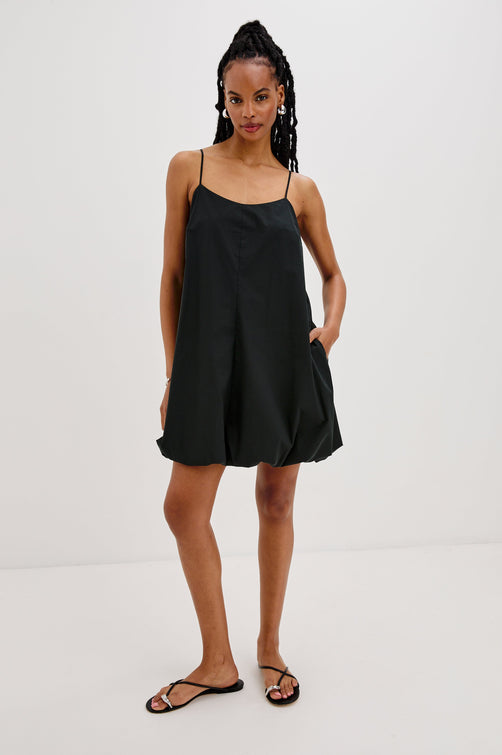 Blanca Bubble Hem Mini Dress with Spaghetti Straps, Hidden Side Zipper and Side Pockets. Full Body Front View Shown on Model.