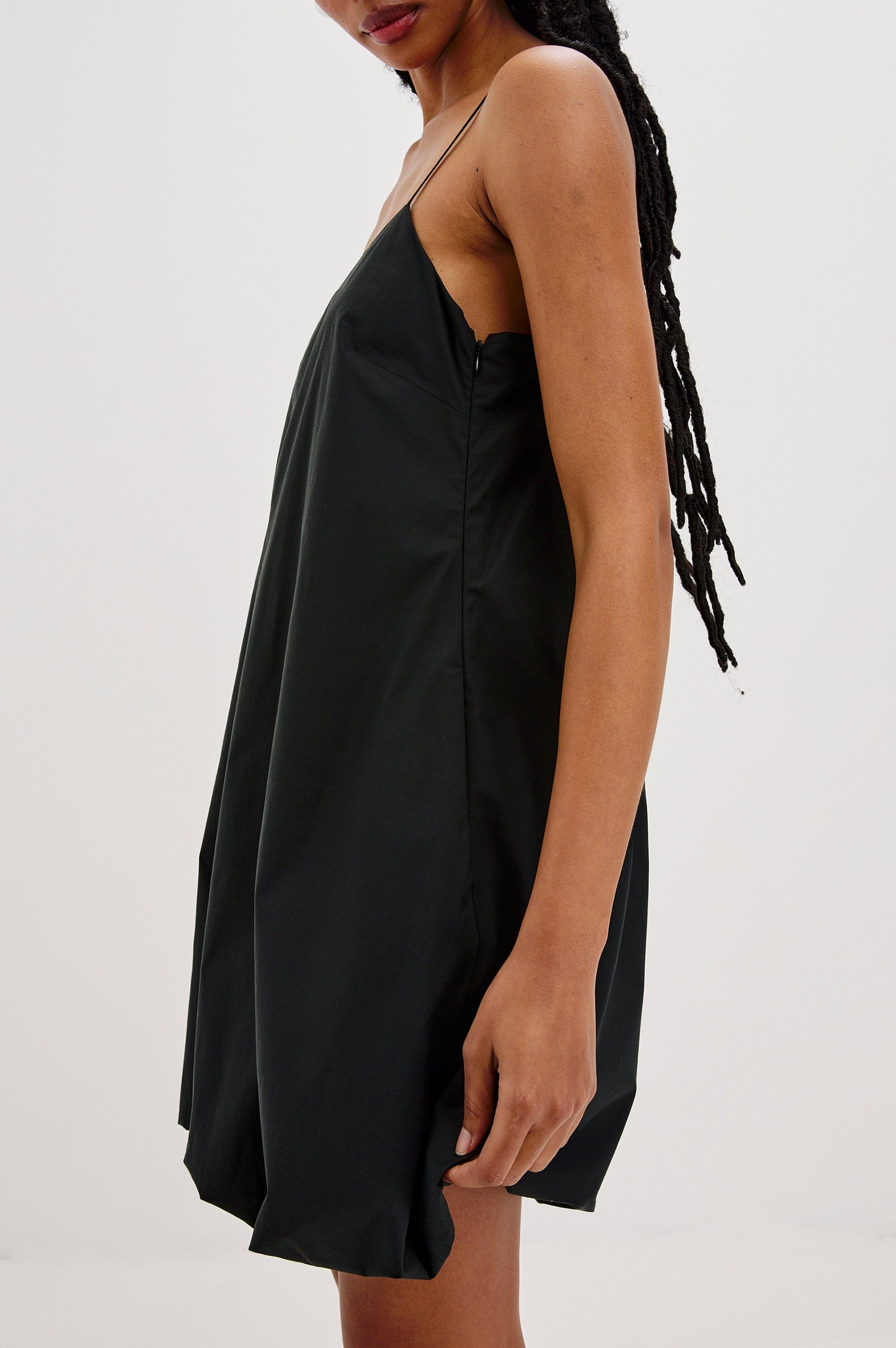 Blanca Bubble Hem Mini Dress with Spaghetti Straps and Side Pockets. Side View Shown on Model.