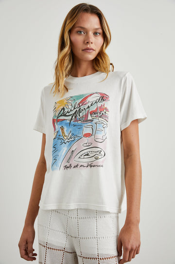 Boyfriend T-Shirt with a Crew Neck, a seaside image and the text, Rails Marseille Rails et en Vacances in Rails Marseille Colorway, with text and image in black and pinks on a White shirt - Front View Featured on Model
