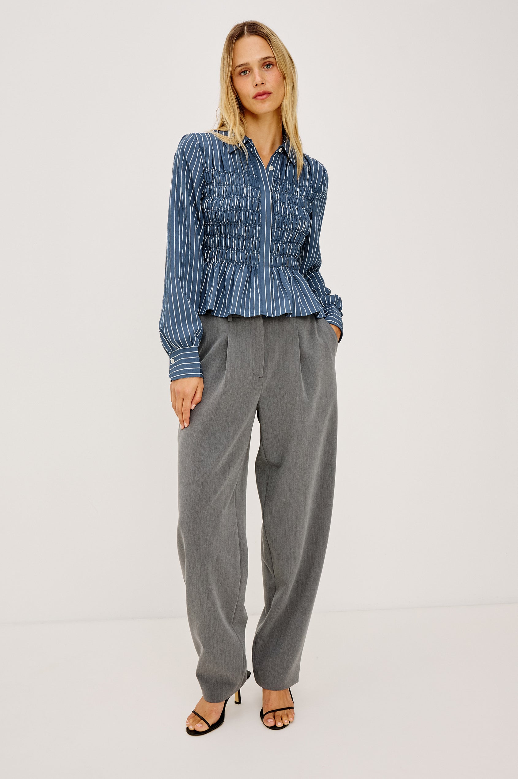 Bradshaw Shirt in Cotton Poplin With Button-Up Front, Collar, Smocked Body, Peplum Hem, and Bishop Sleeves in Washed Indigo Stripe Colorway - Full Body Front View Featured on Model