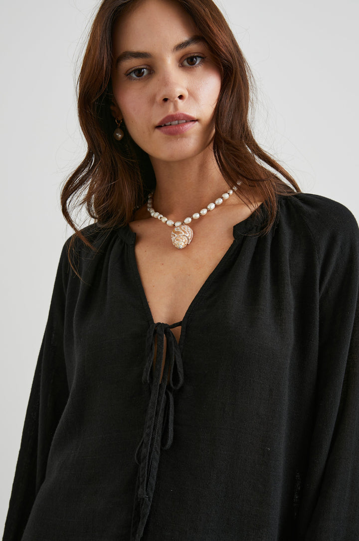 Brielle Long-Sleeve Top with a Deep V Neck with Ties and Pleats around the Neckline in Black Colorway - Front View Featured on Model