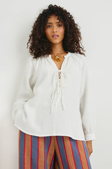 Brielle Long-Sleeve Top with a Deep V Neck with Ties and Pleats around the Neckline in White Colorway - Front View Featured on Model