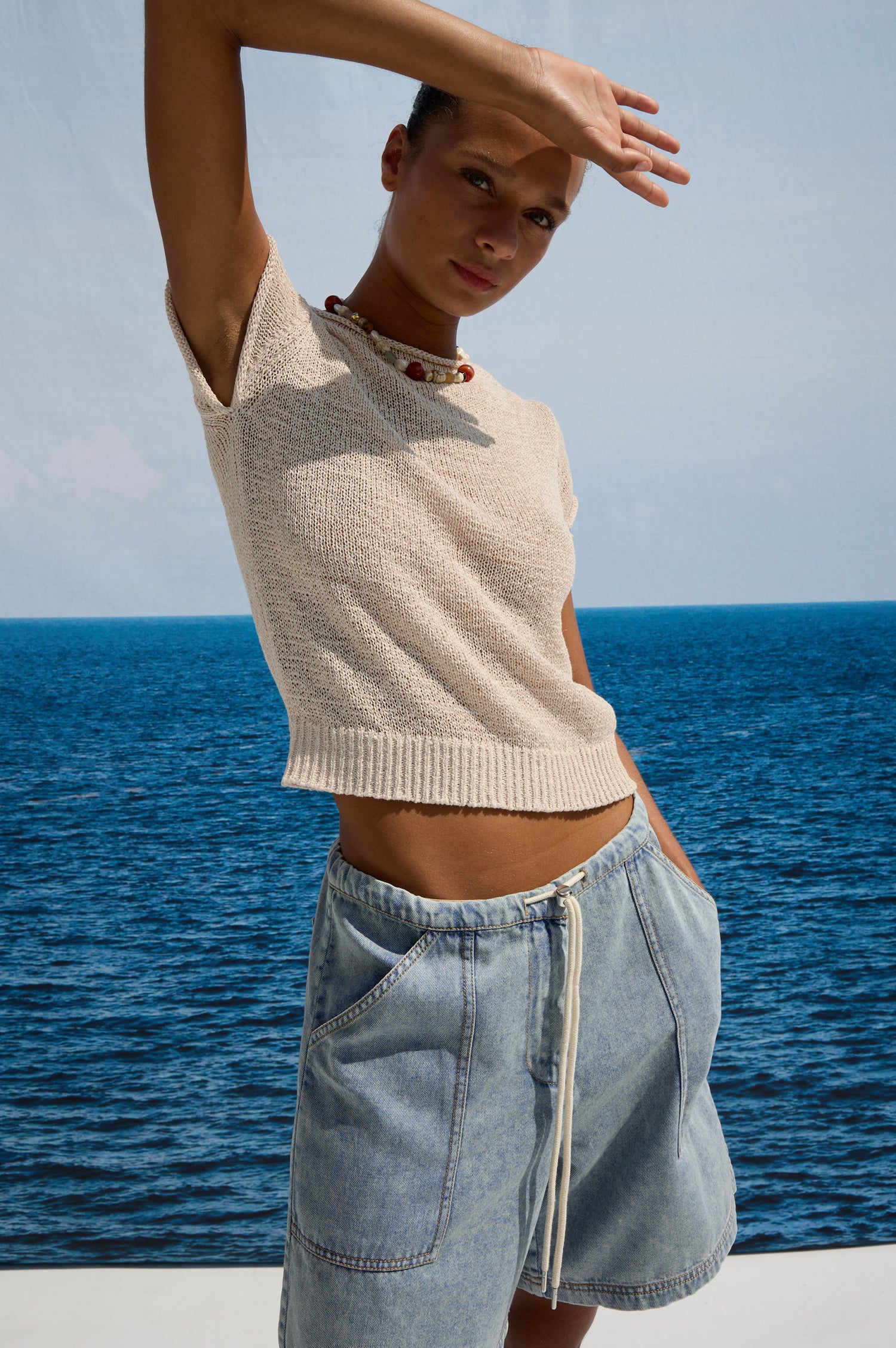 Cady Top in Semi-Sheer Linen-Blend Knit With Rolled Neckline, Cap Sleeves, and Classic Fit in IStone Colorway - Upper Body Front View Featured on Model